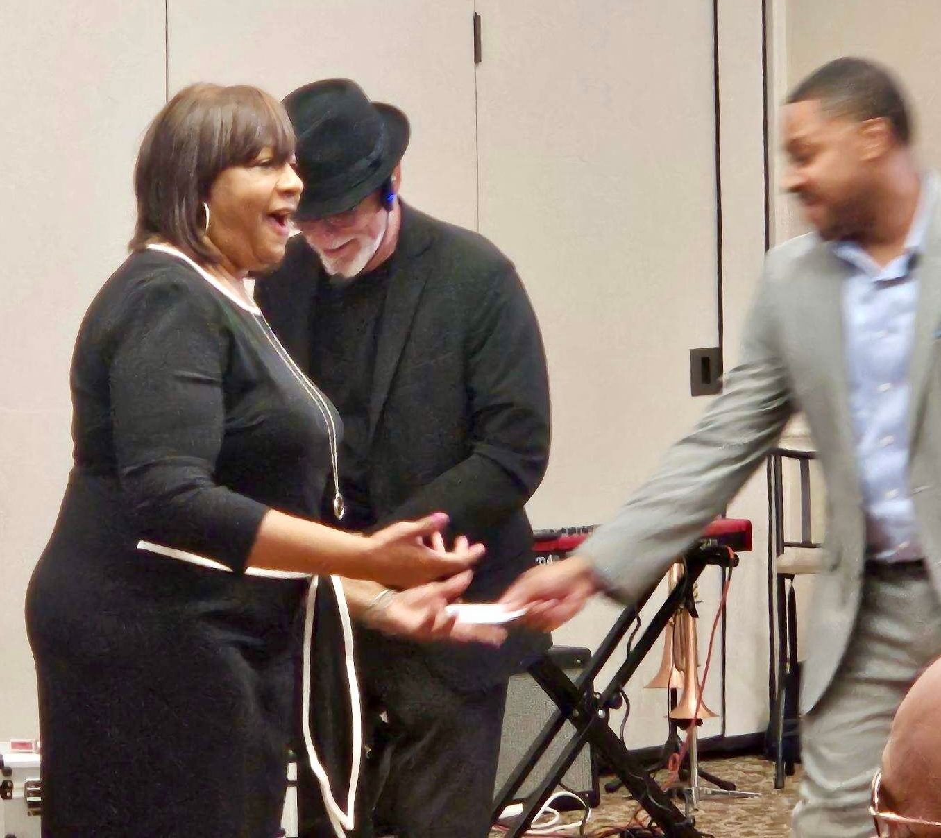 A woman in a black dress is talking to a man in a suit.