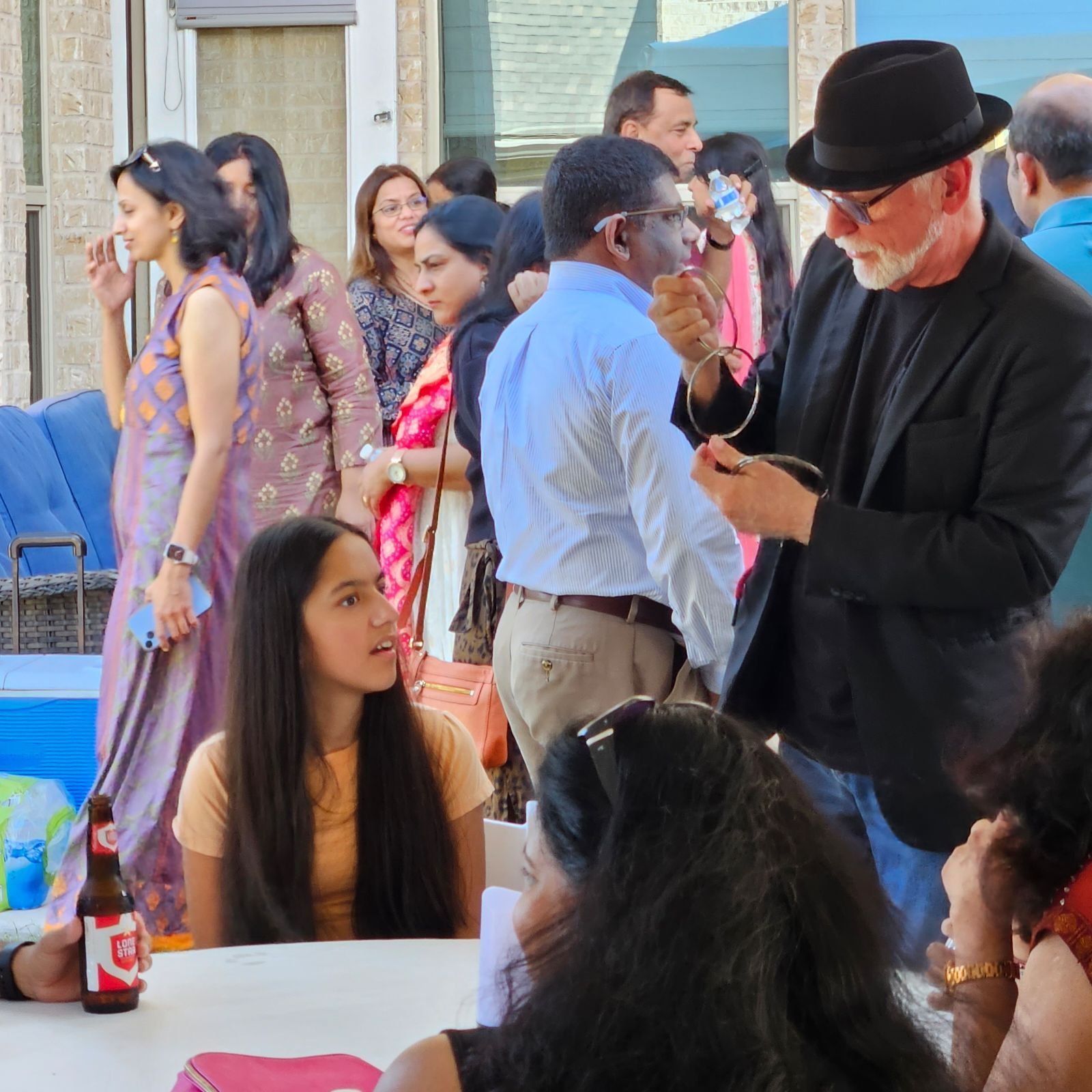 A group of people gather around a table.