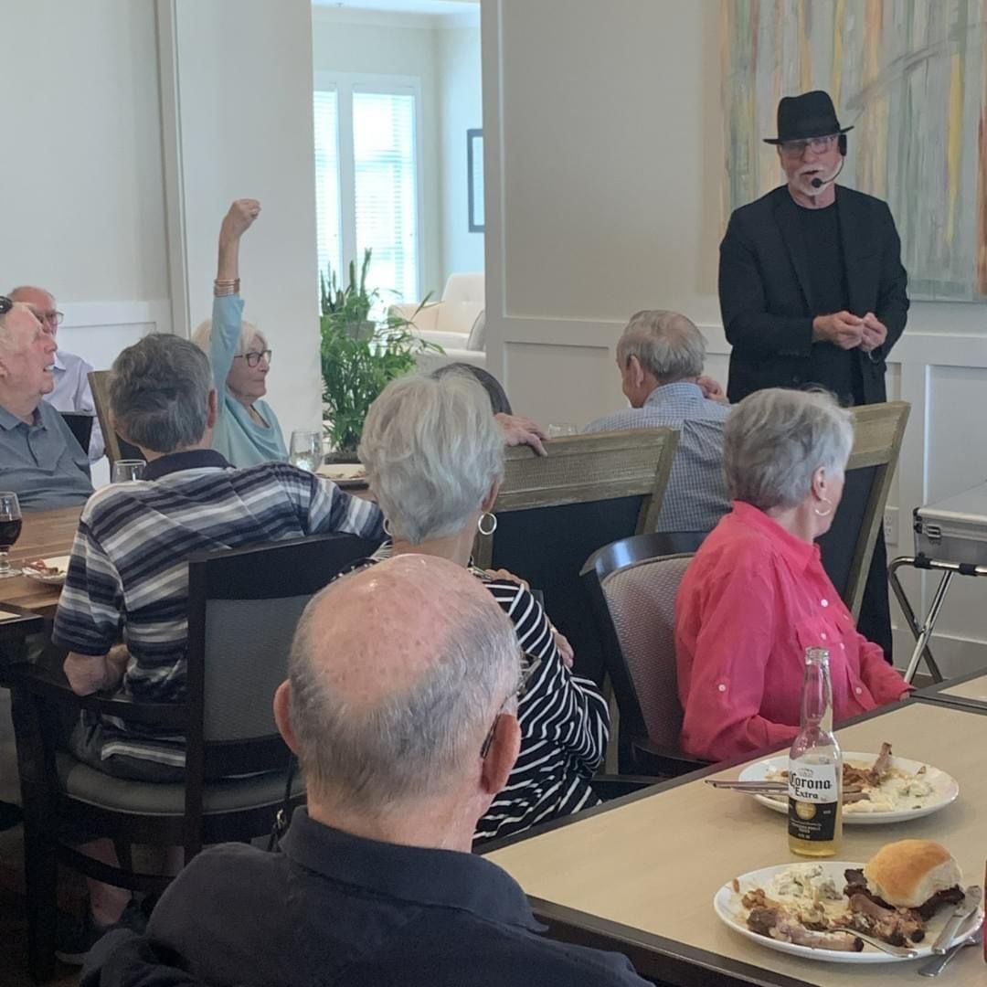 A man in a hat is giving a presentation to a group of people.