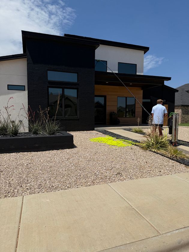 Modern house with gravel yard and a person standing near the front entrance