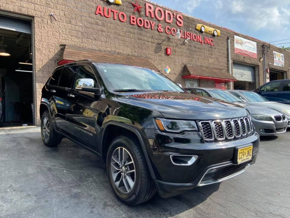 A black Jeep Grand Cherokee is parked in front of a building