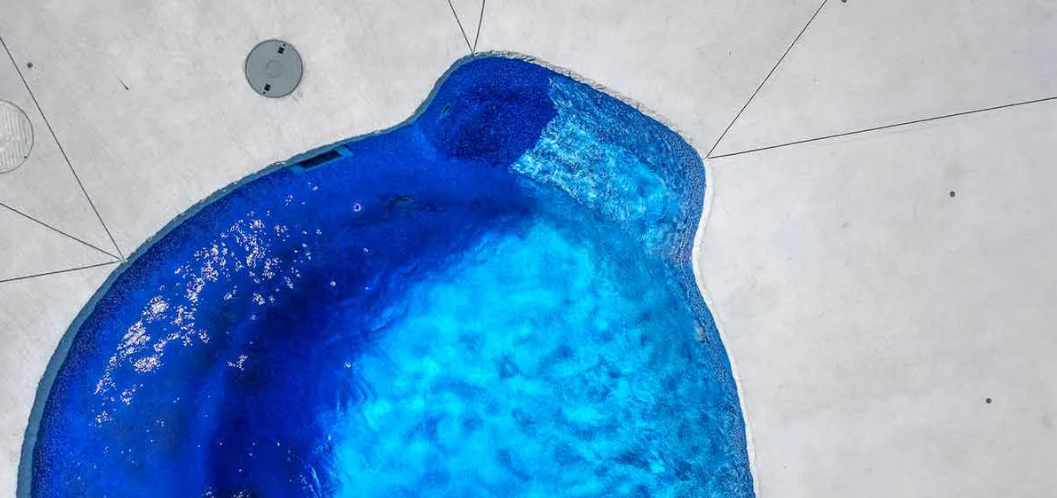 A close-up of a blue, blob-like shape with textured surface, on a light background with faint markings.