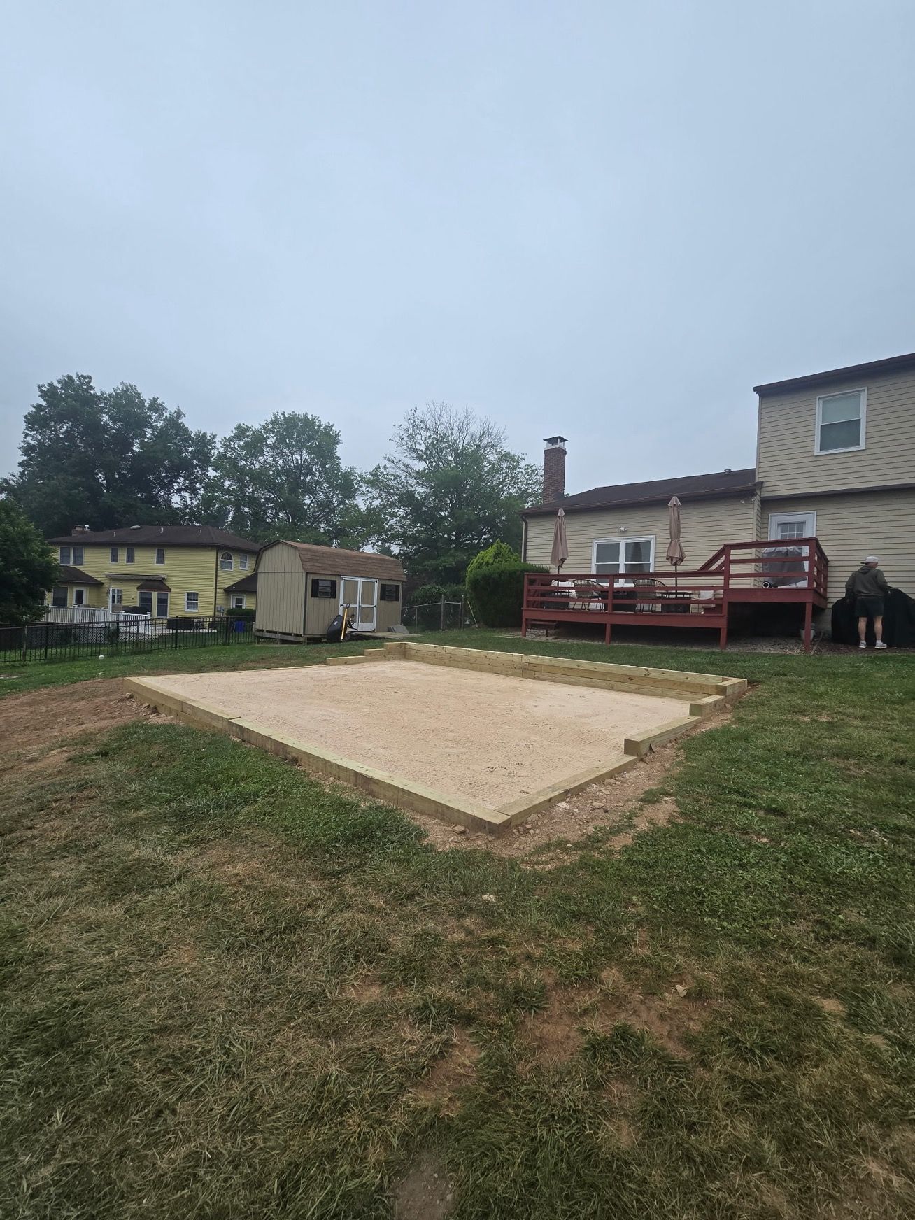 A large grassy field with a house in the background.