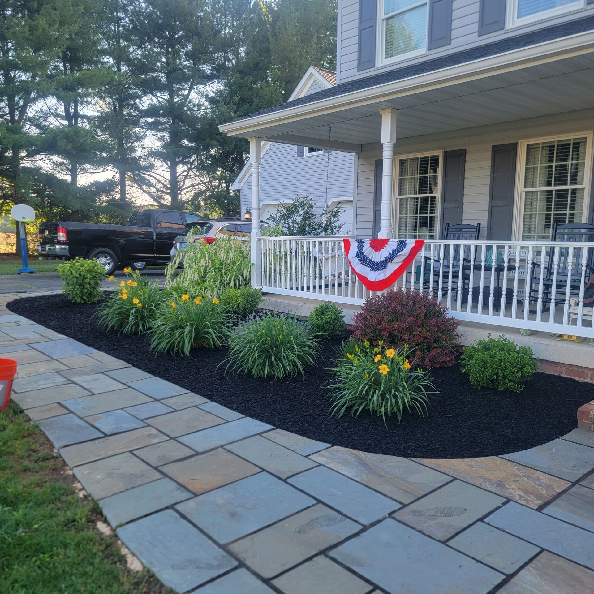 A red white and blue flag is hanging on the porch of a house