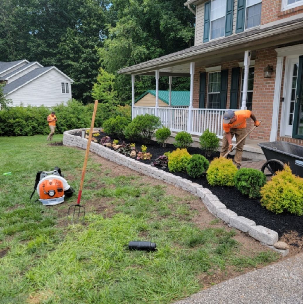 A man is working on a lawn in front of a house.