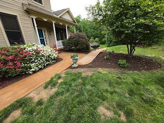 There is a walkway leading to the front of the house.