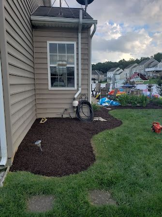 A house with a window and a drain pipe in the backyard.