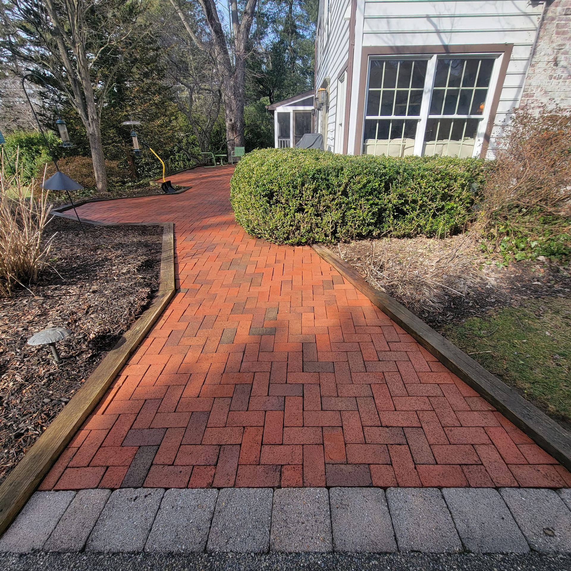 A brick walkway leading to a white house