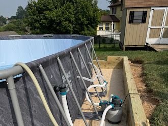 A swimming pool is being built in a backyard next to a house.