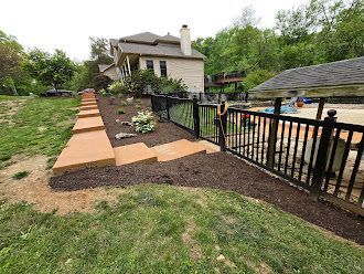 A house with a fence and stairs in front of it.