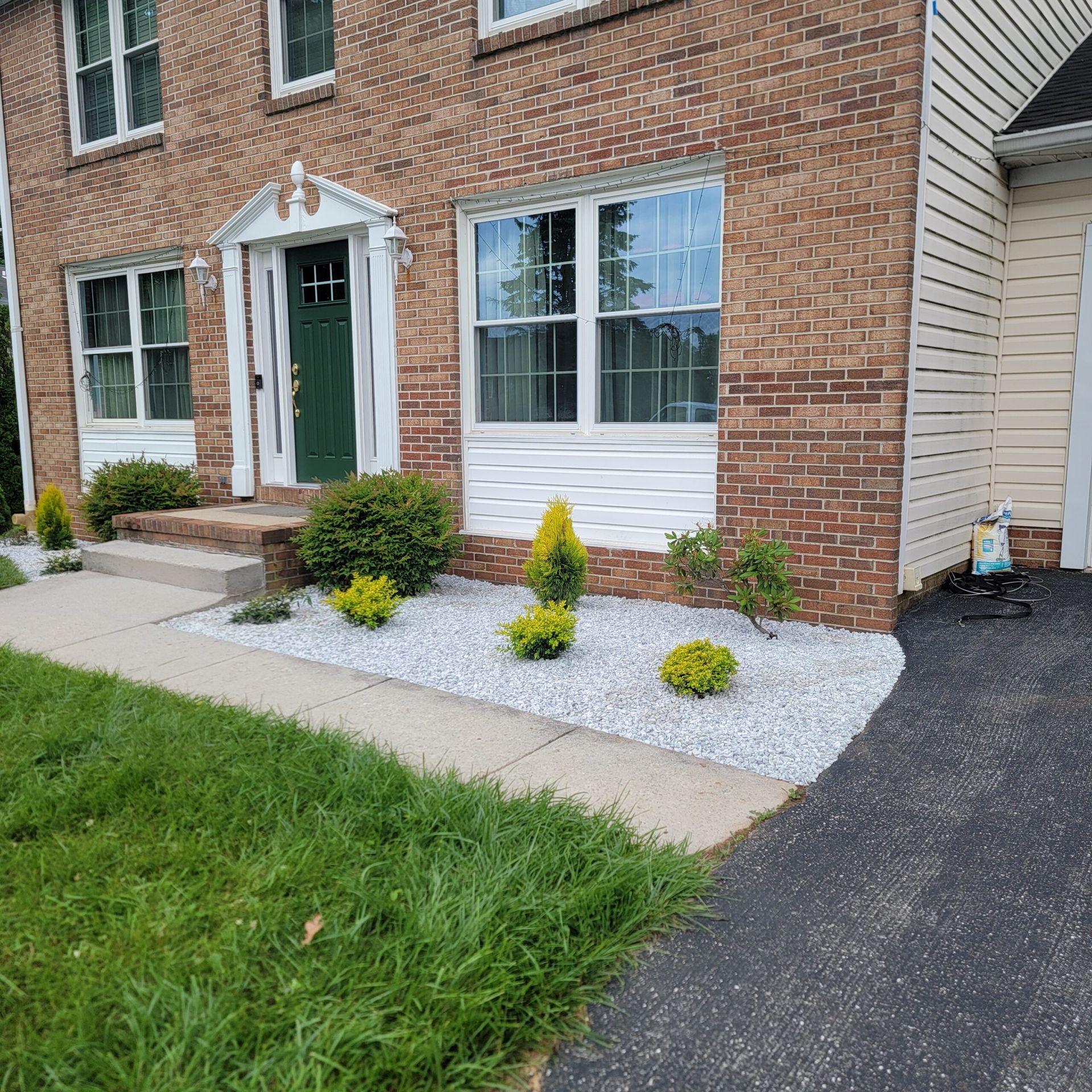 A brick house with a gravel garden in front of it.