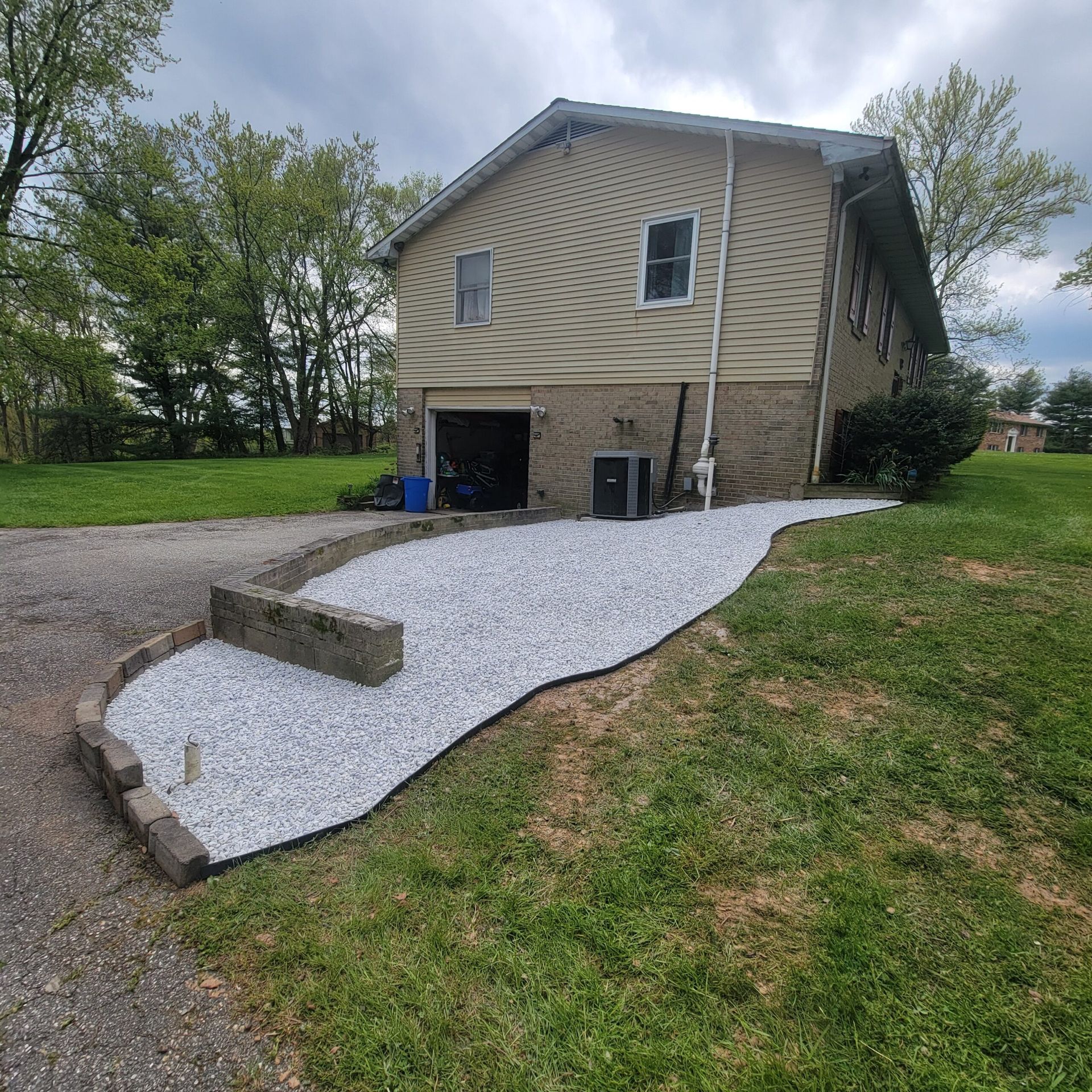 A house with a gravel driveway leading to it