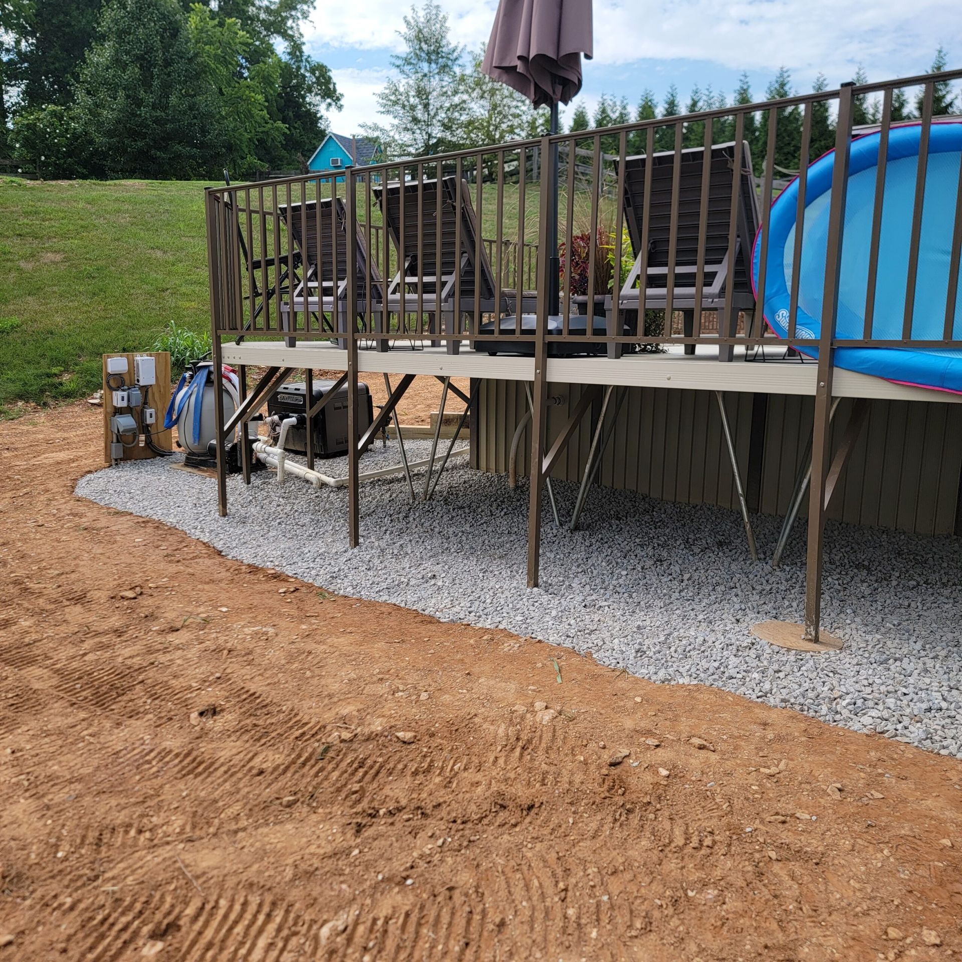 A deck with chairs and umbrellas next to a pool