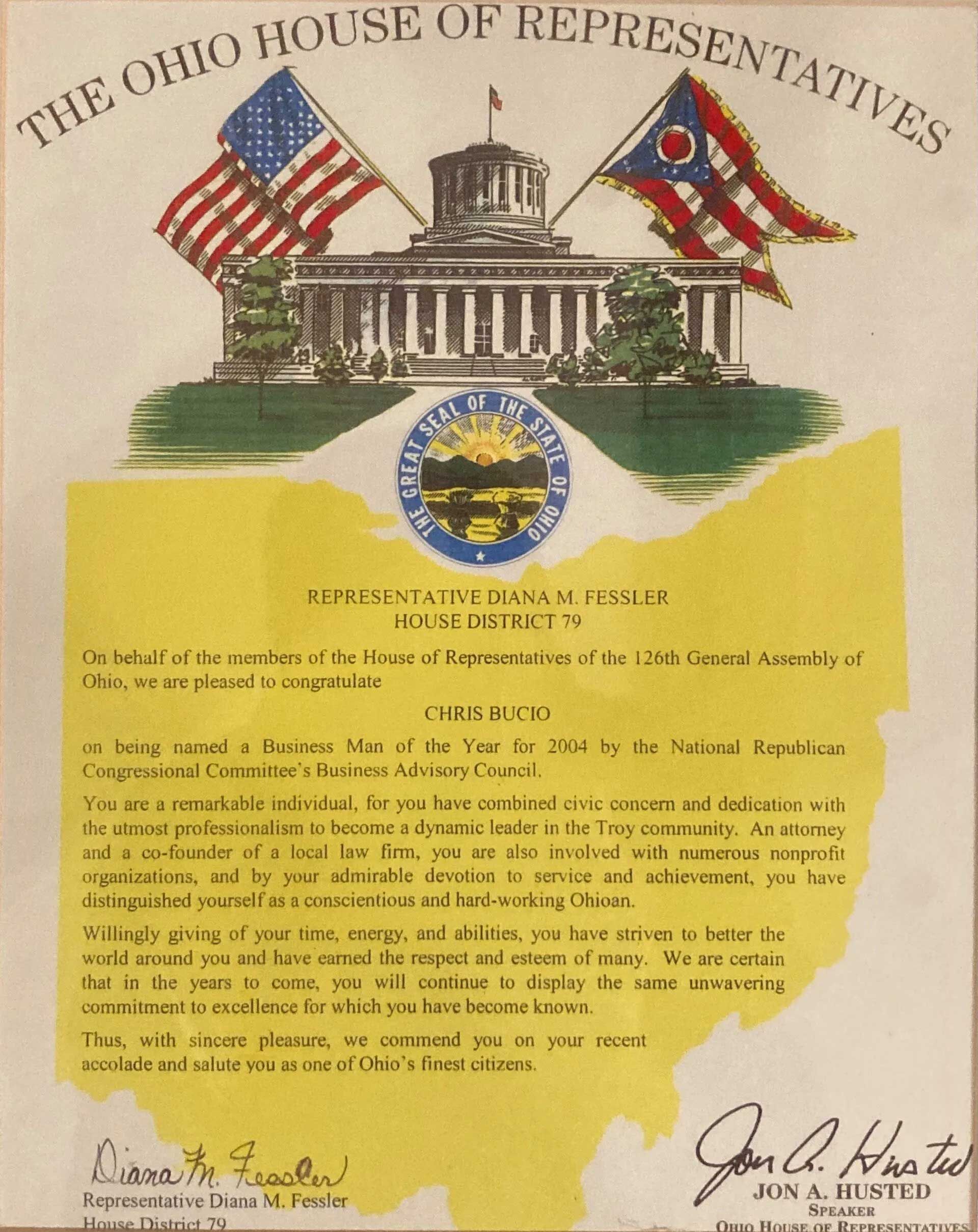 An Ohio House of Representatives commendation document on a yellow outline of the state with the state capitol building.