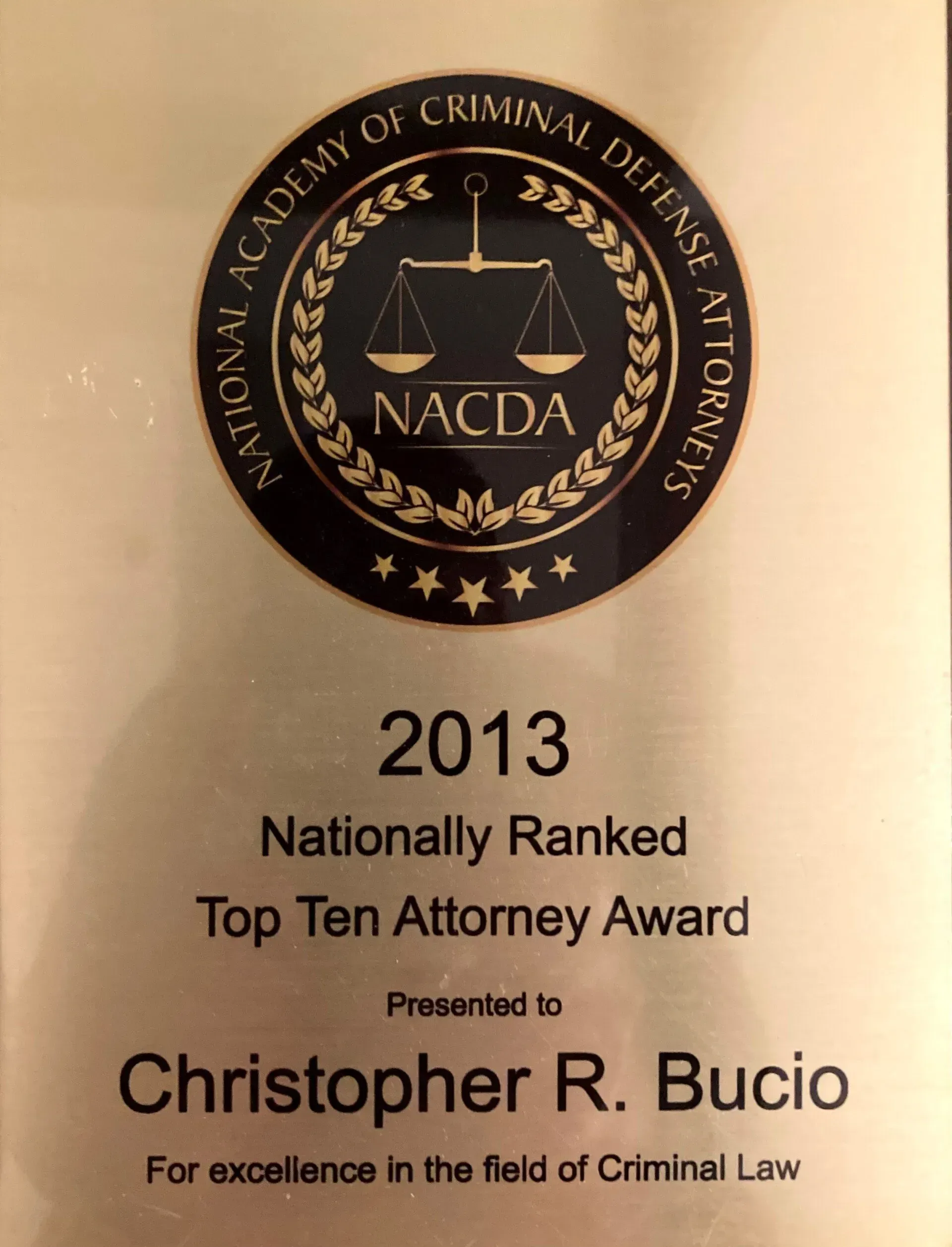 A 2013 National Academy of Criminal Defense Attorneys plaque awarded to Christopher R. Bucio for excellence in criminal law.