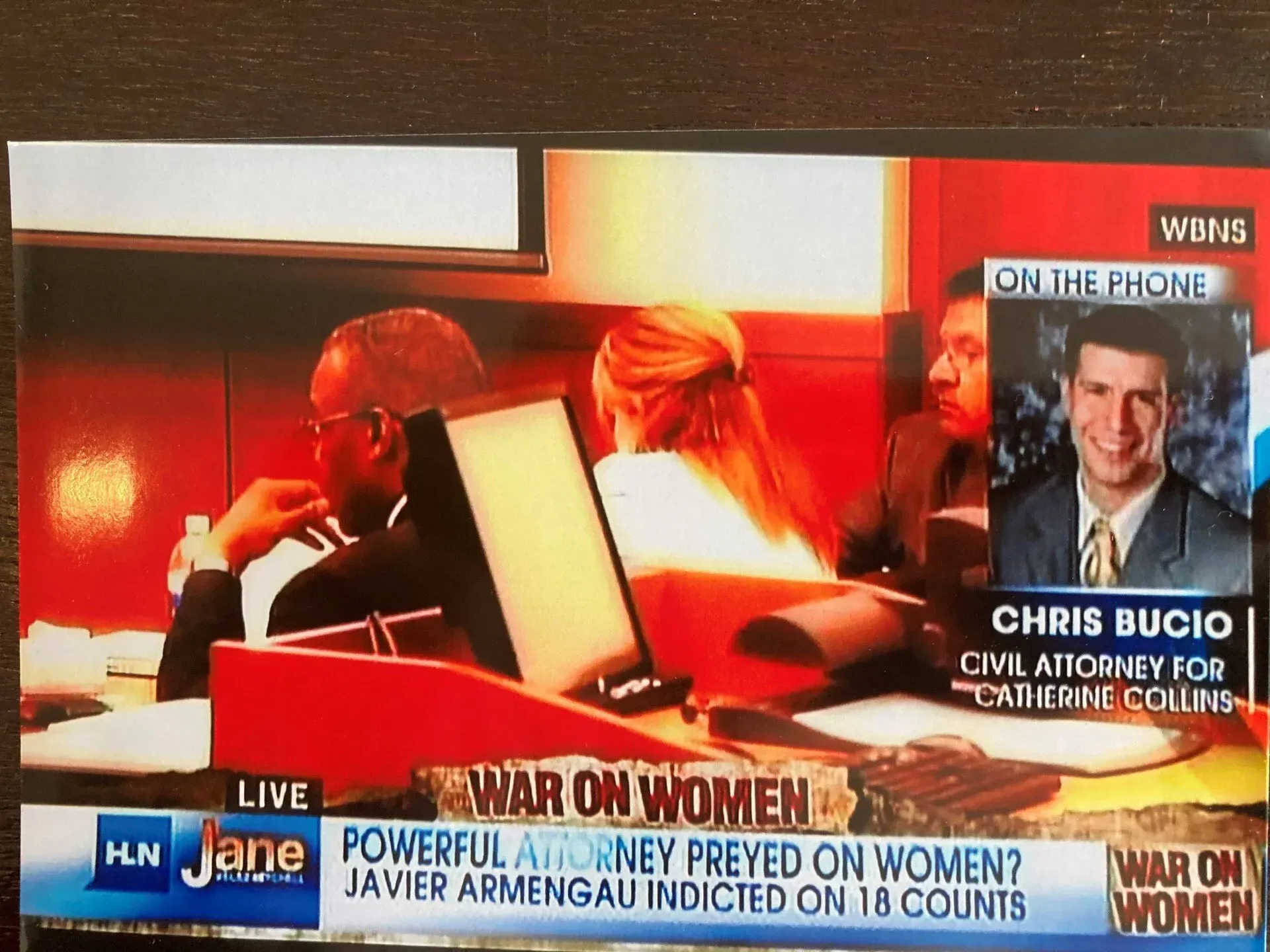 A news broadcast screen with a banner reading 