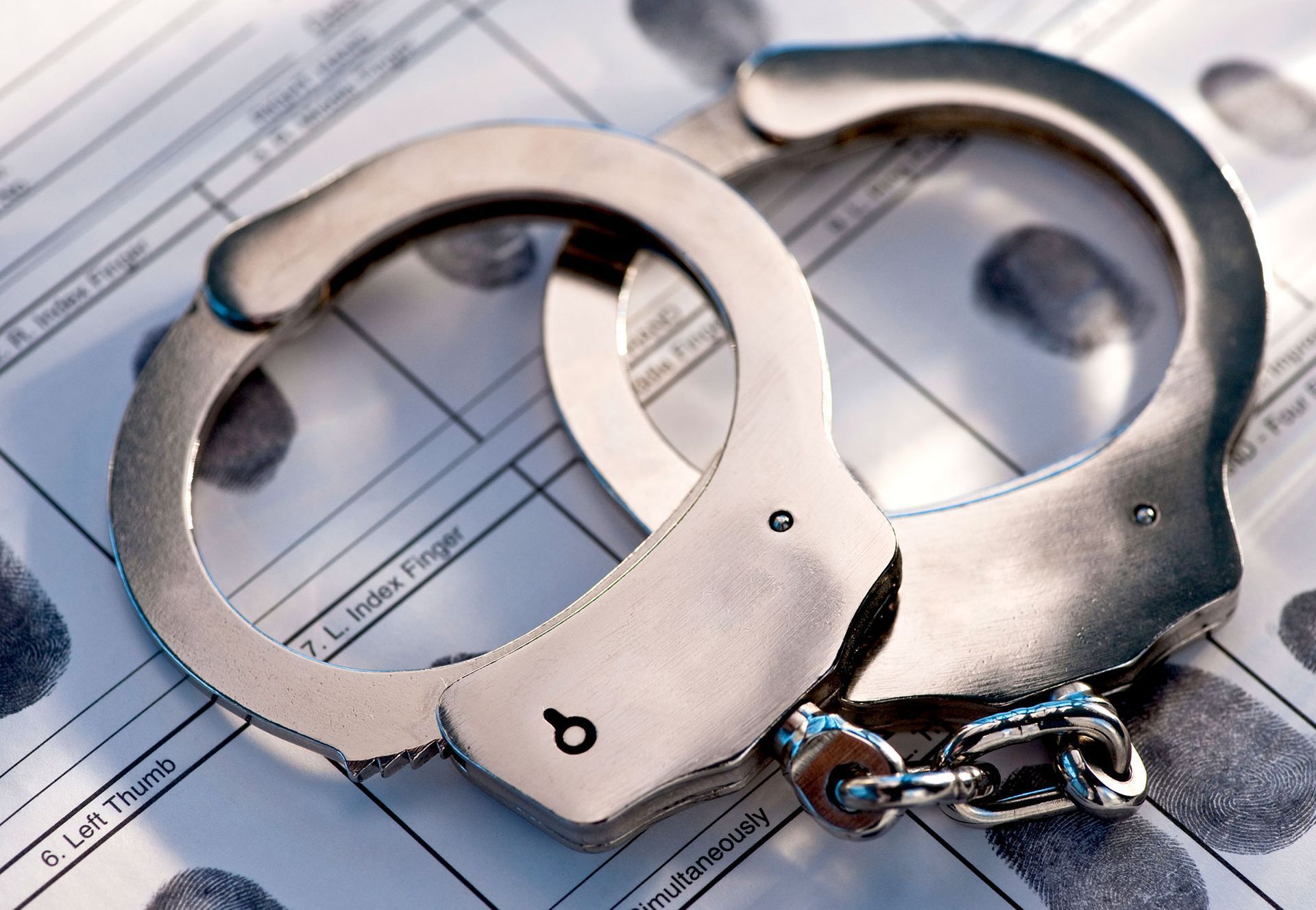 Handcuffs on a fingerprint record form.