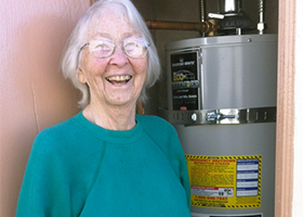 Old lady and a water heater on the background