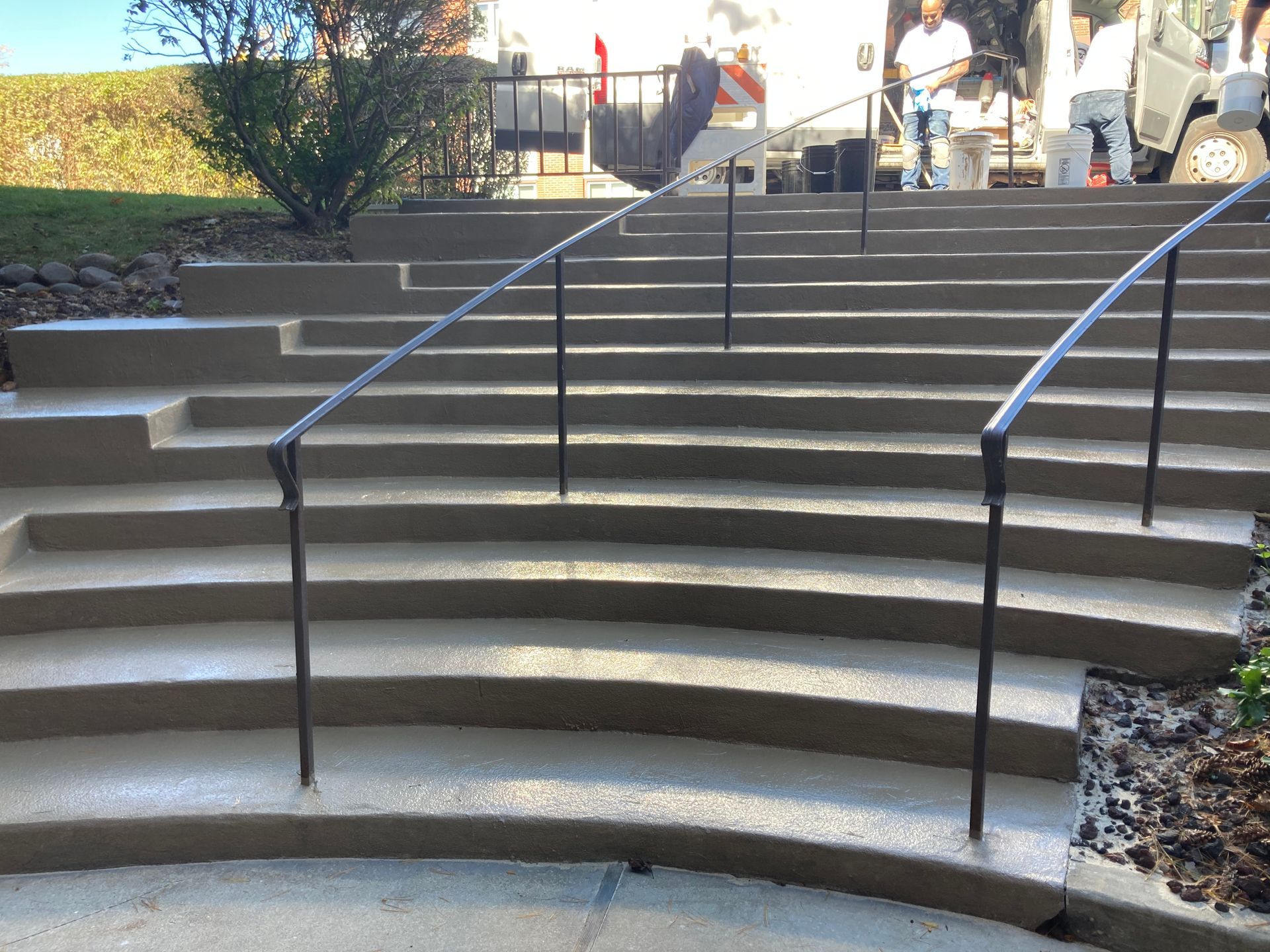 a set of concrete stairs with a metal railing
