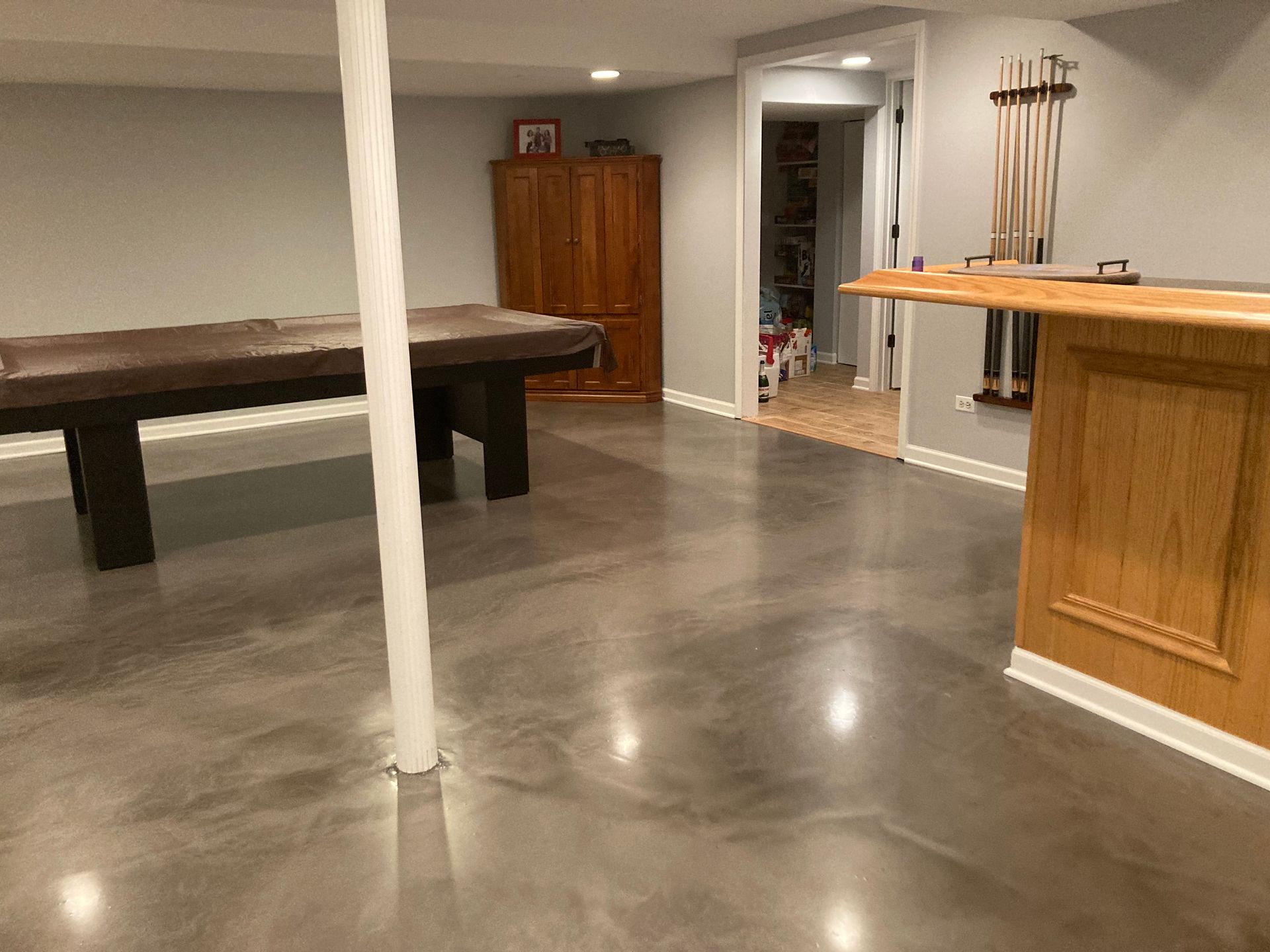 a basement with a pool table and a bar