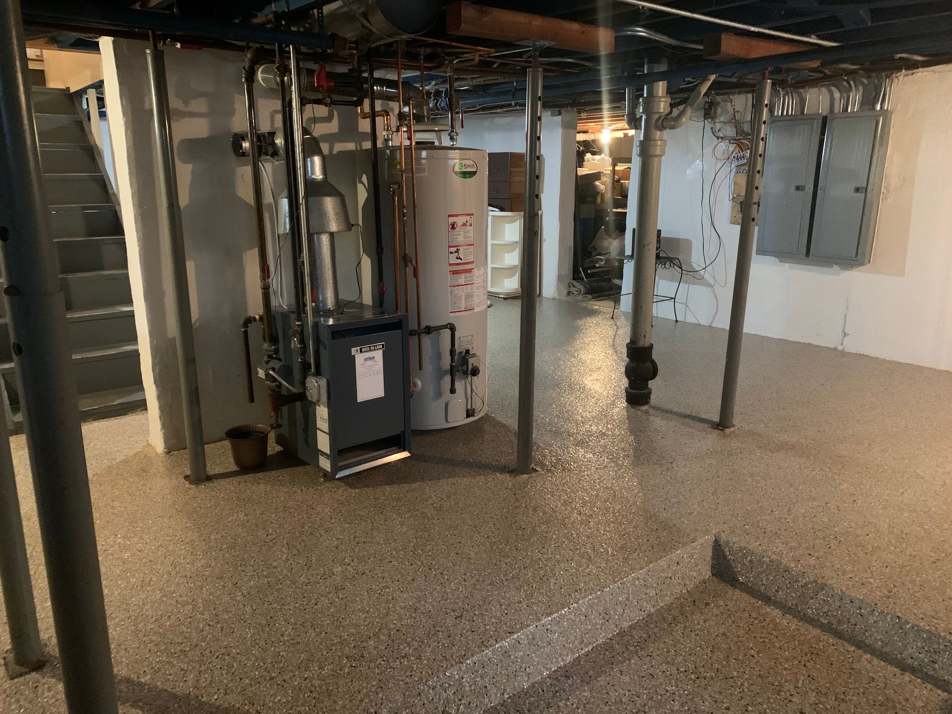 a basement with a water heater and stairs
