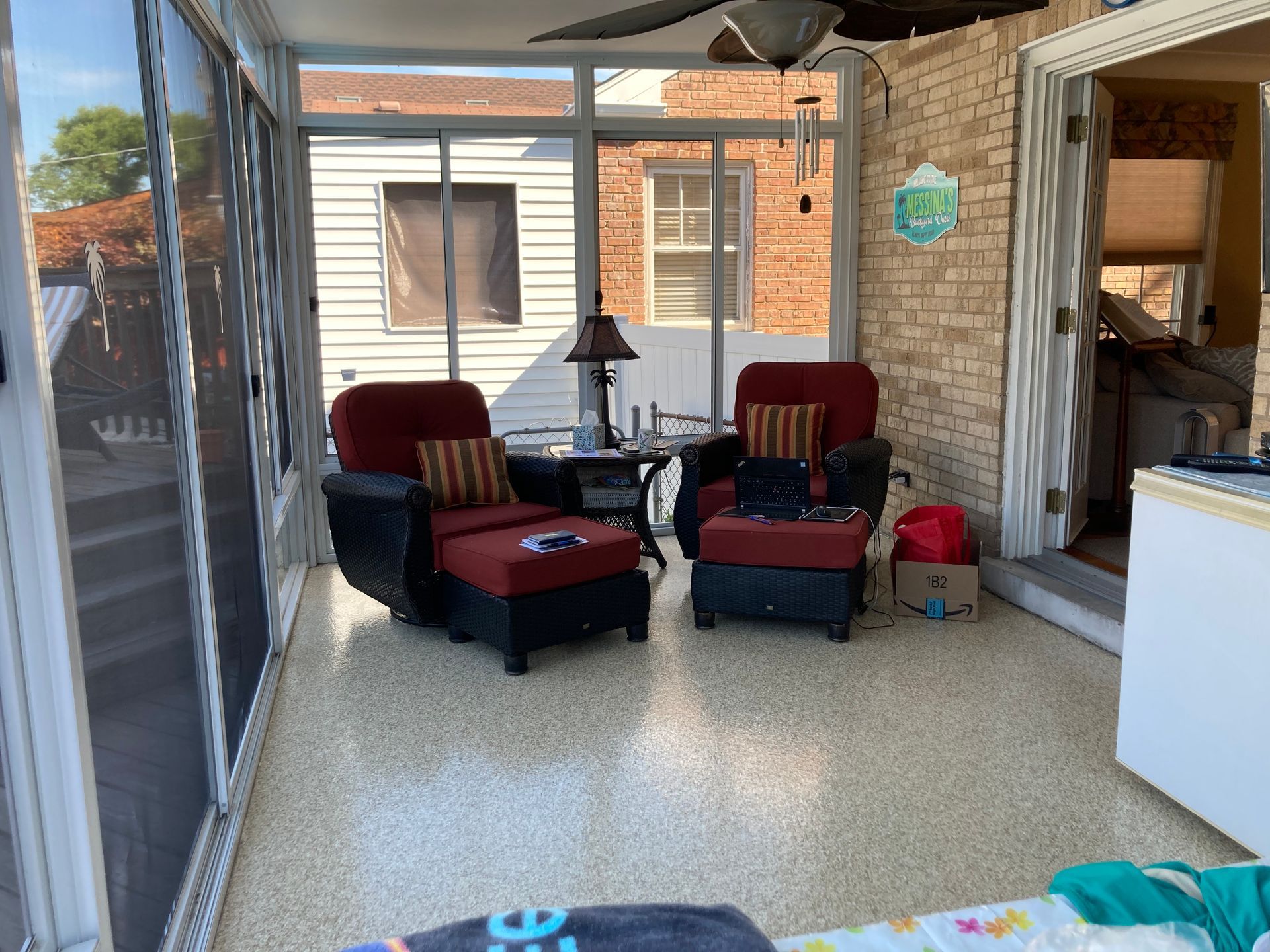a screened in porch with chairs and a ceiling fan