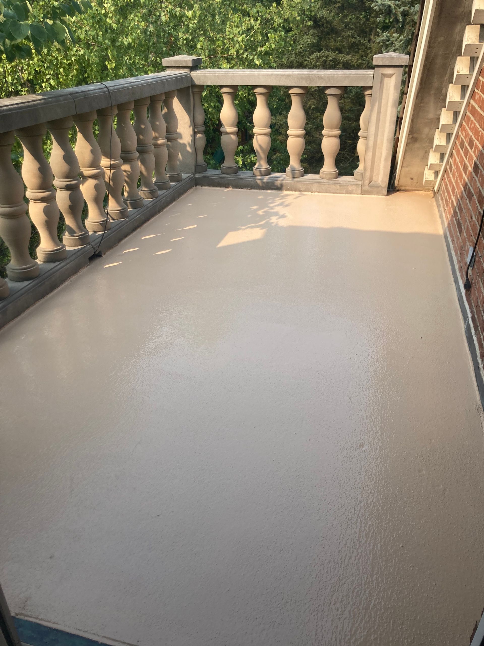 a balcony with a railing and a concrete floor