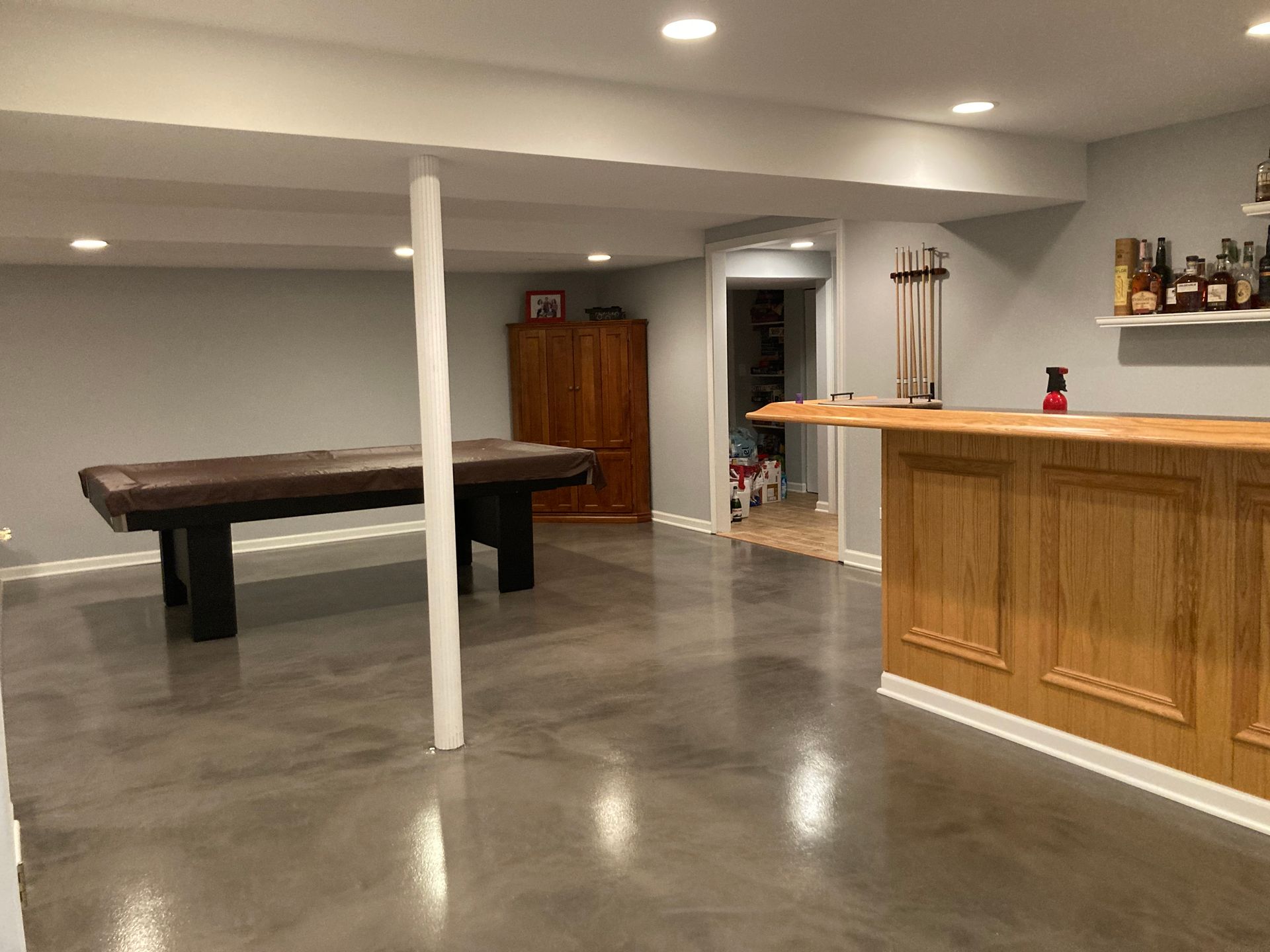 a basement with a pool table and a bar