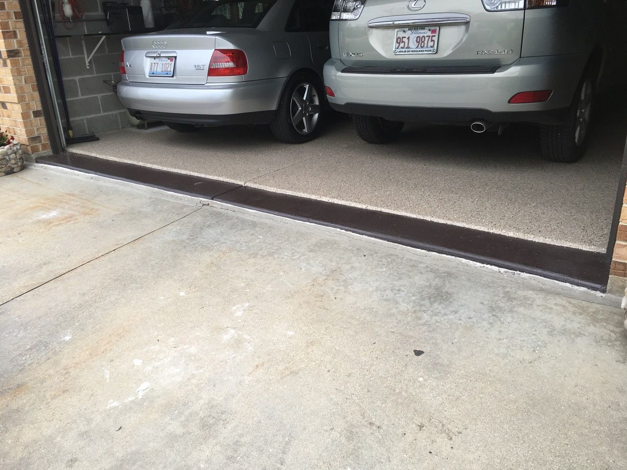 two cars are parked in a garage with a concrete floor
