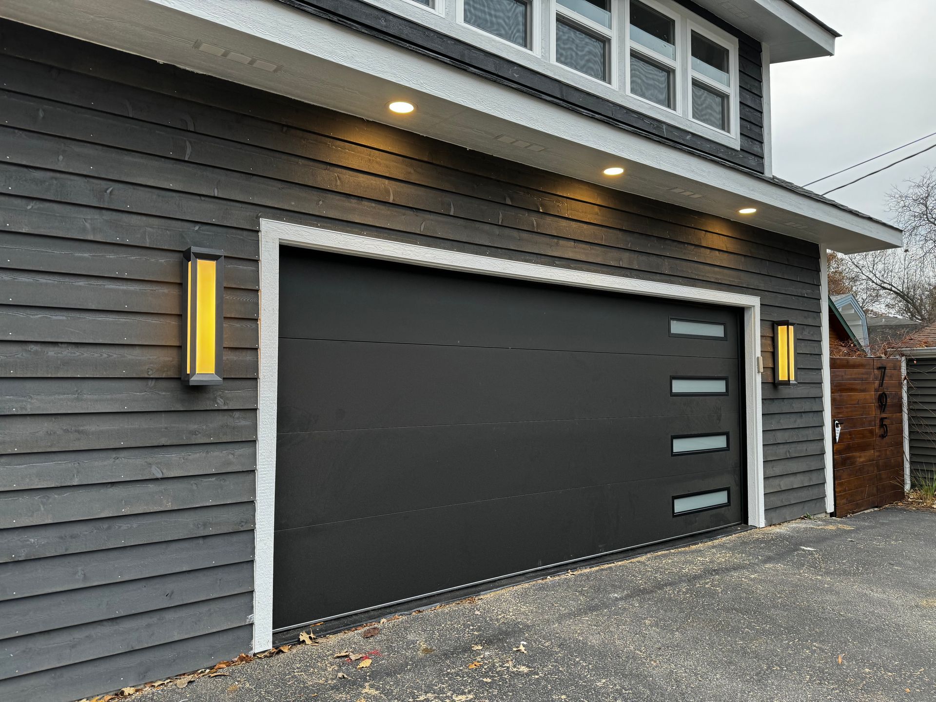 a black garage door is sitting on the side of a house