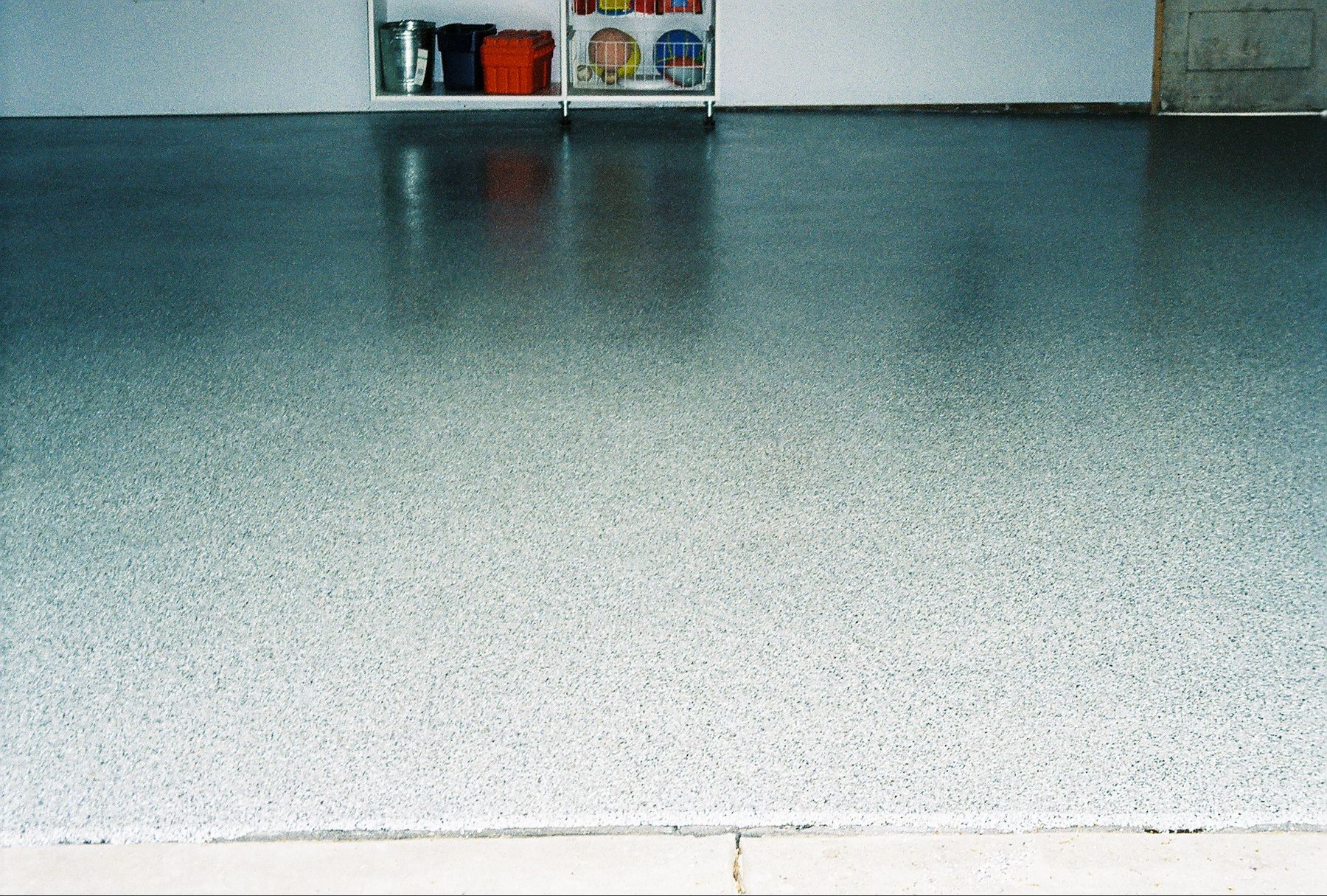 a garage floor with a shelf in the background