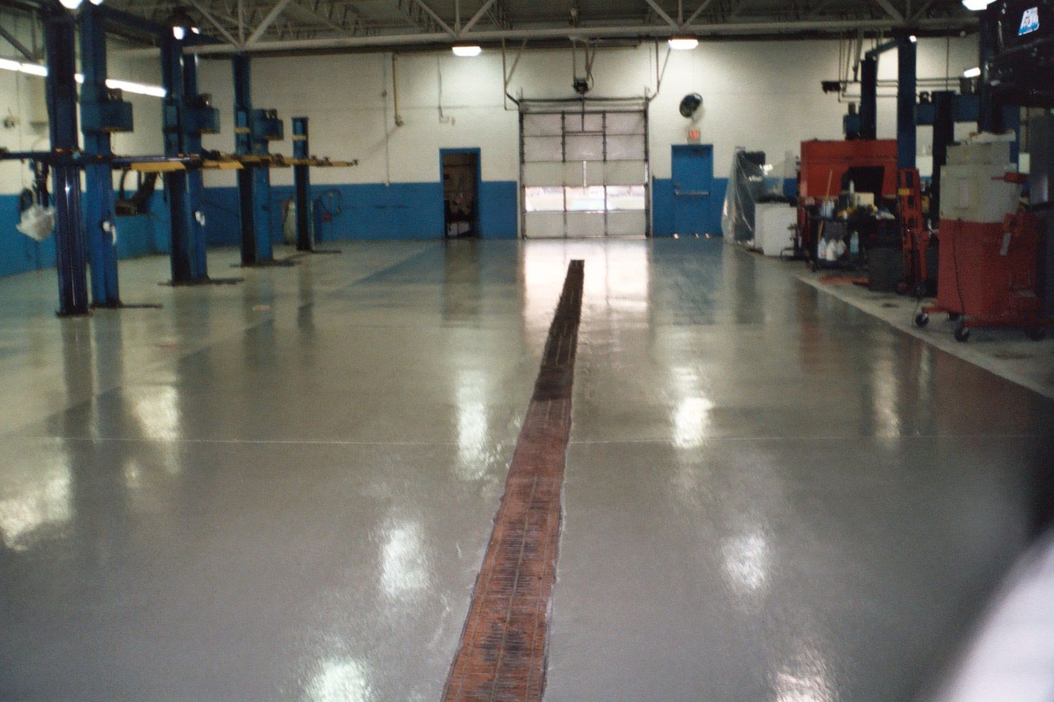 a large empty garage with a drain in the middle
