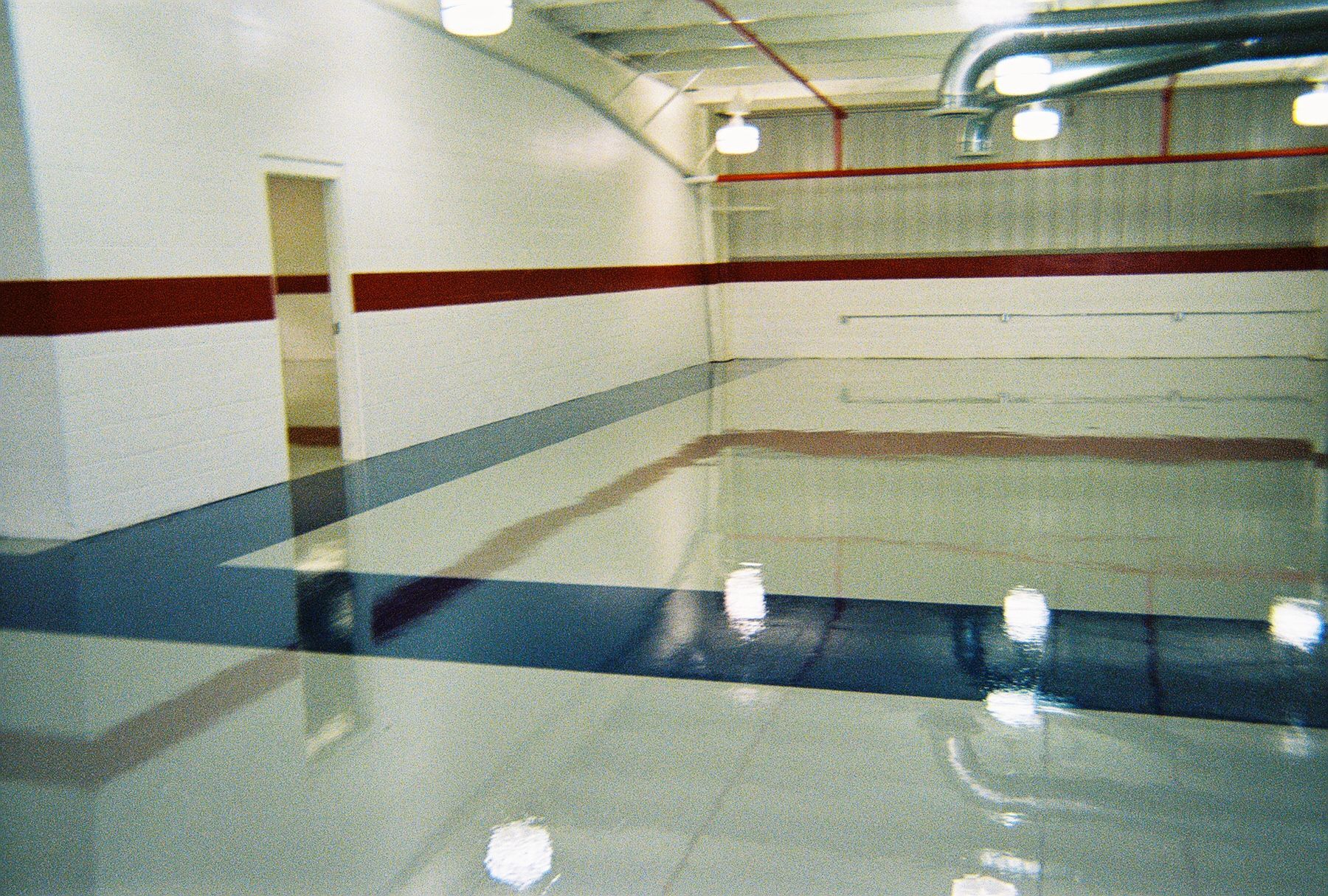 a room with a shiny floor and red and blue stripes on the walls