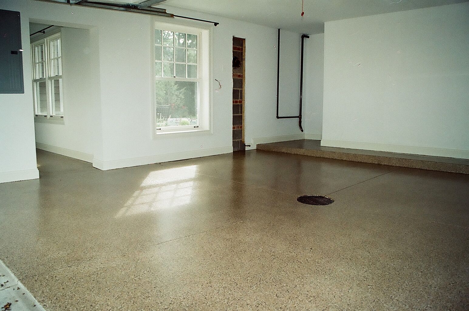 an empty room with a concrete floor and white walls