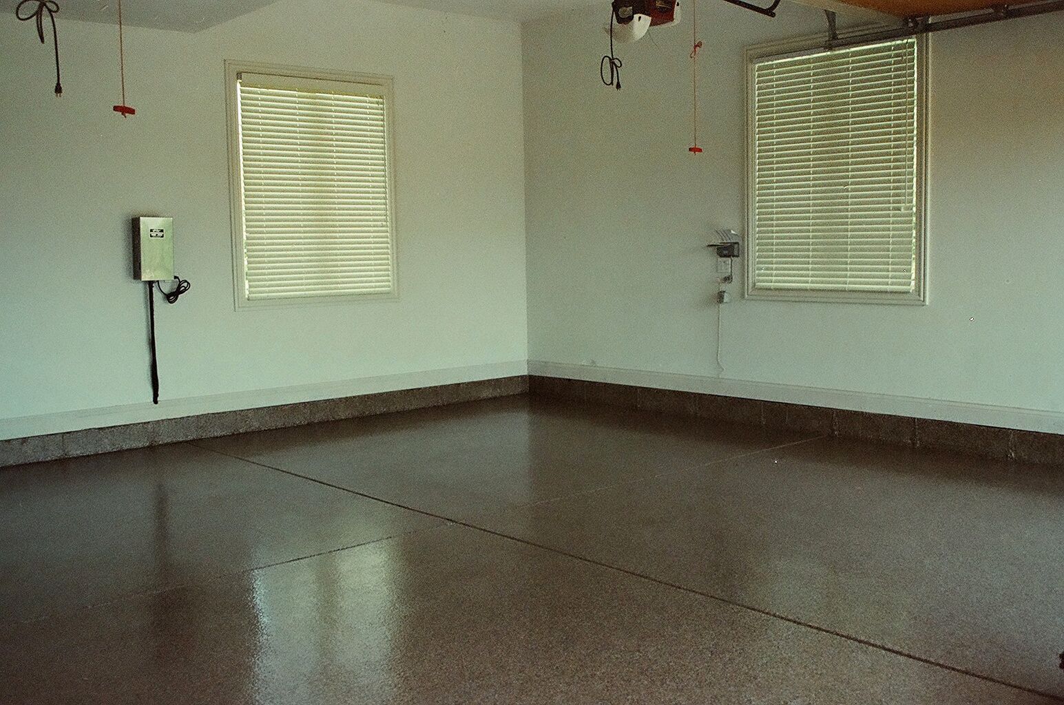 an empty room with a brown floor and white walls