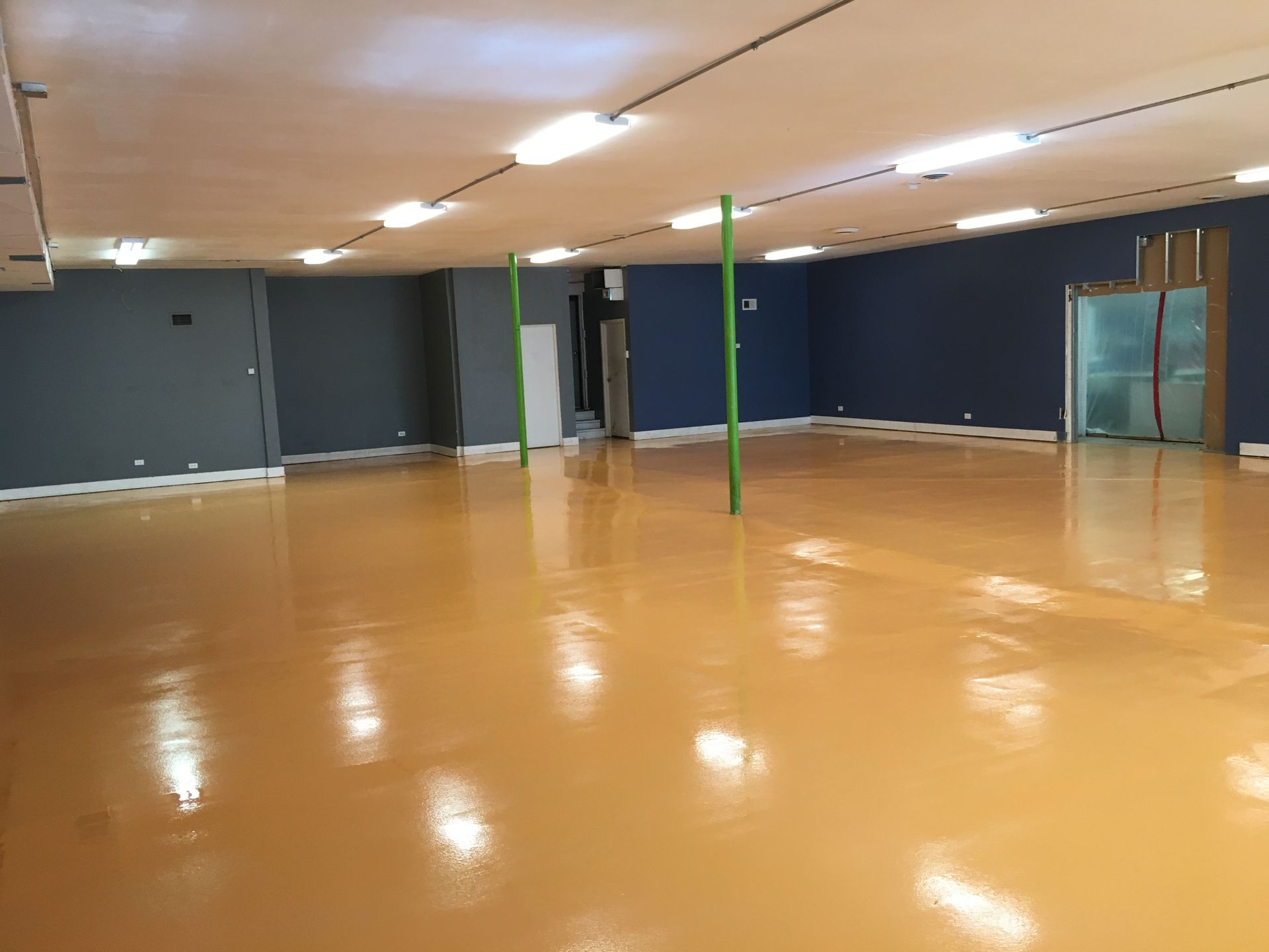 a large empty room with a yellow floor and blue walls