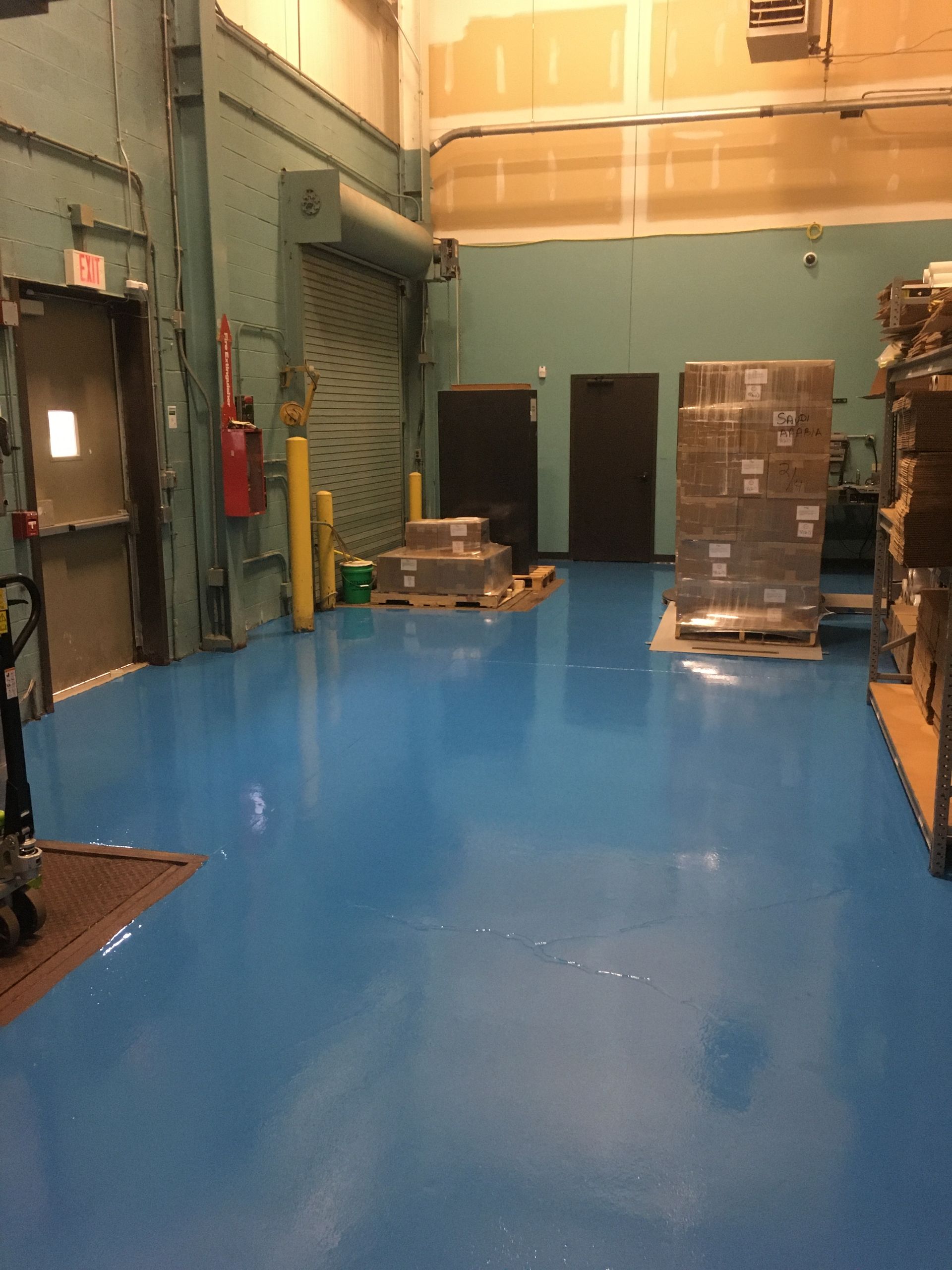 a warehouse with blue floors and boxes on pallets