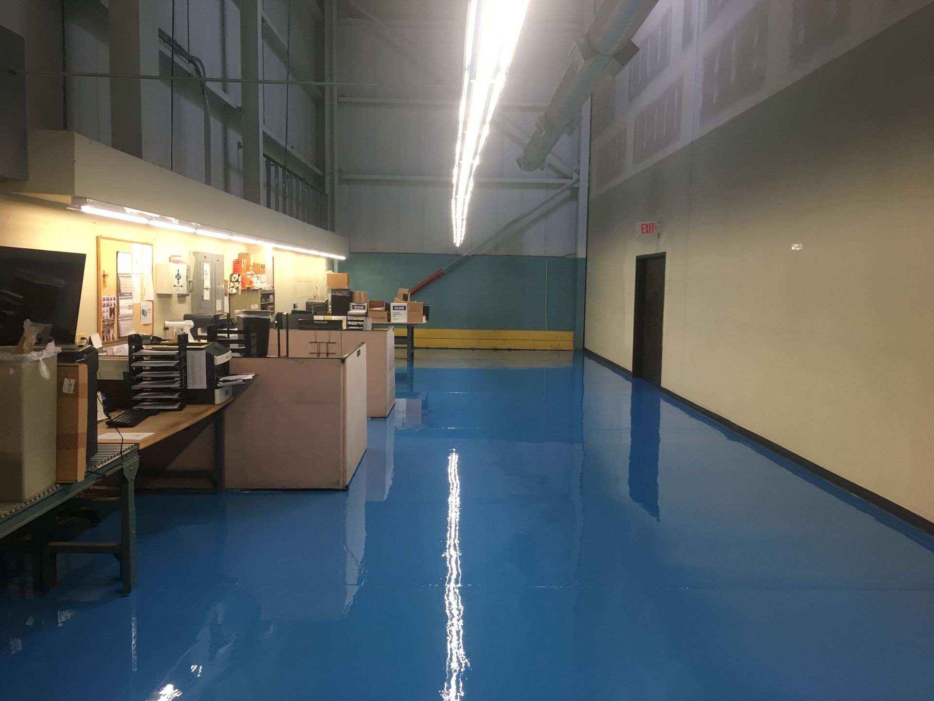 a large room with a blue floor and a lot of desks