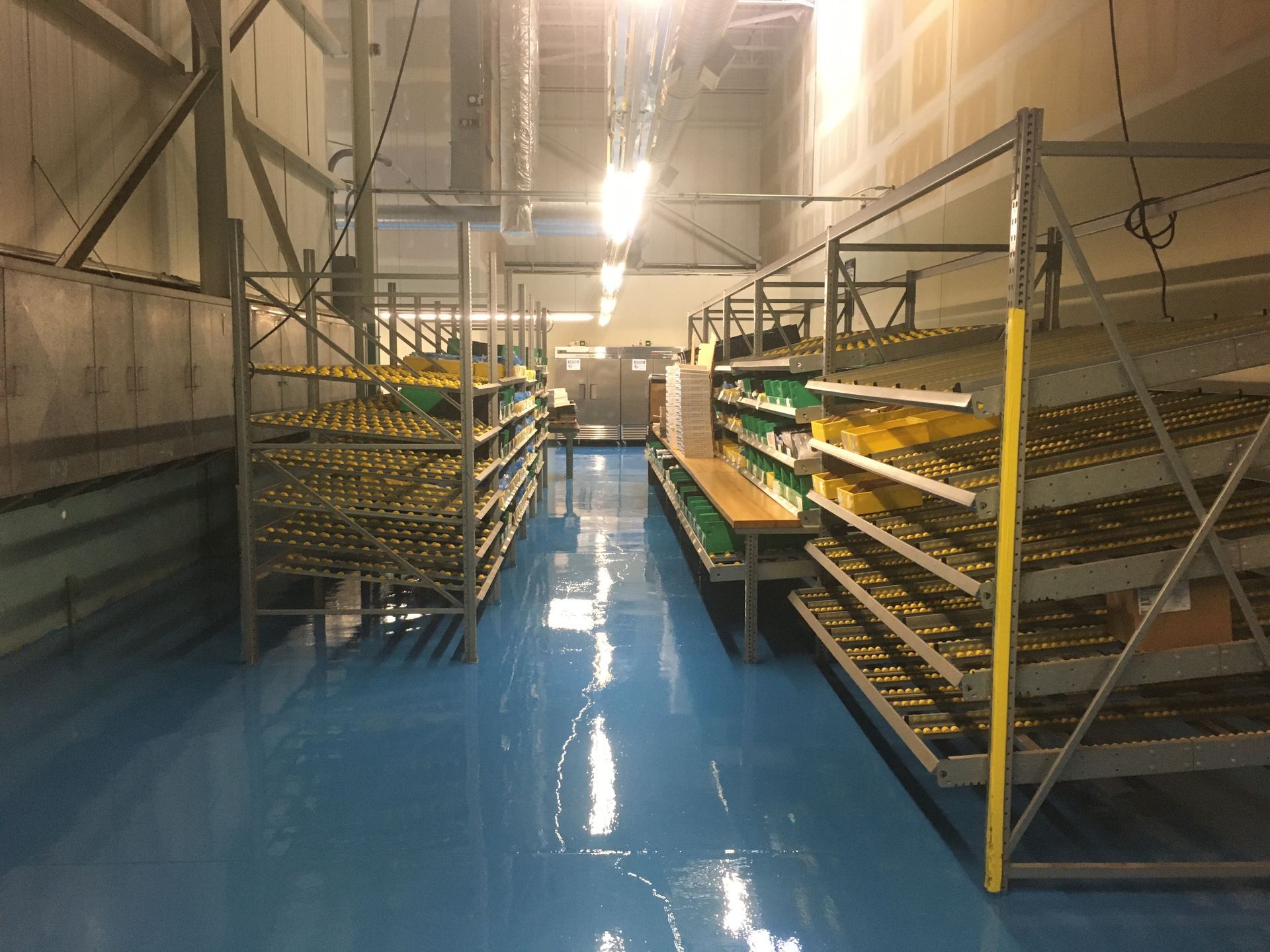 a warehouse with blue floors and lots of shelves