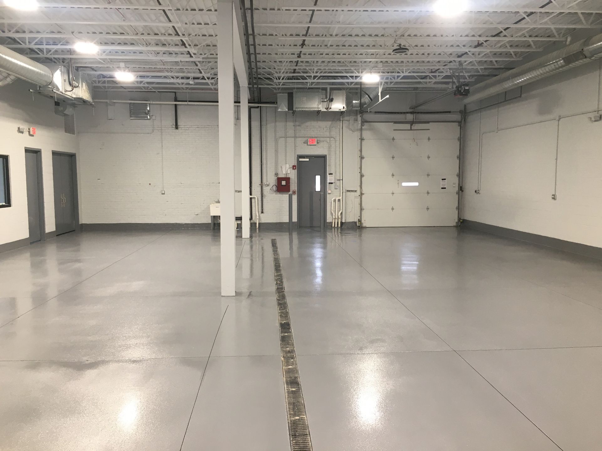 a large empty warehouse with a gray floor and white walls