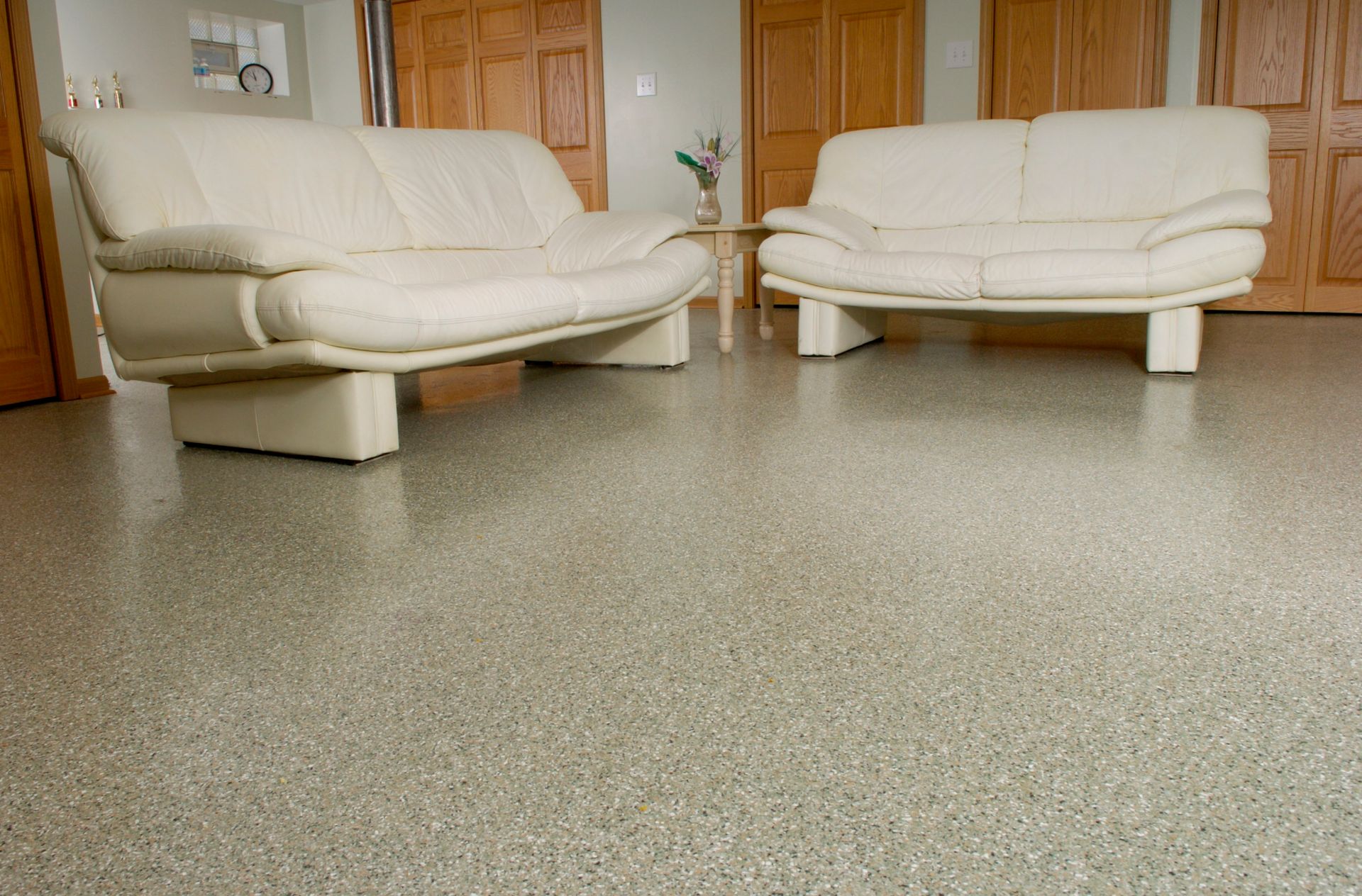 a living room with two white couches and a gray floor