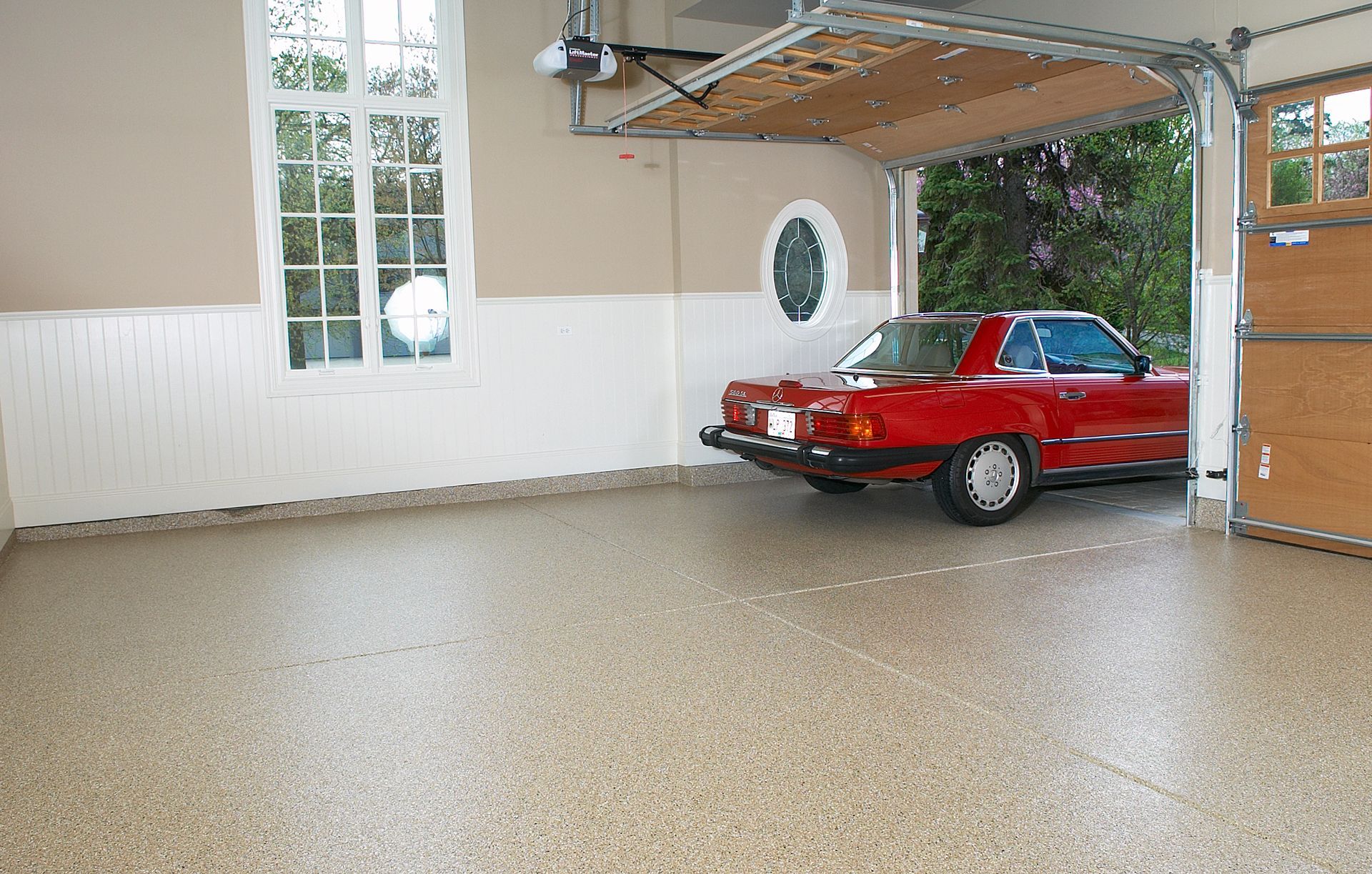 a red car is parked in a garage with the garage door open