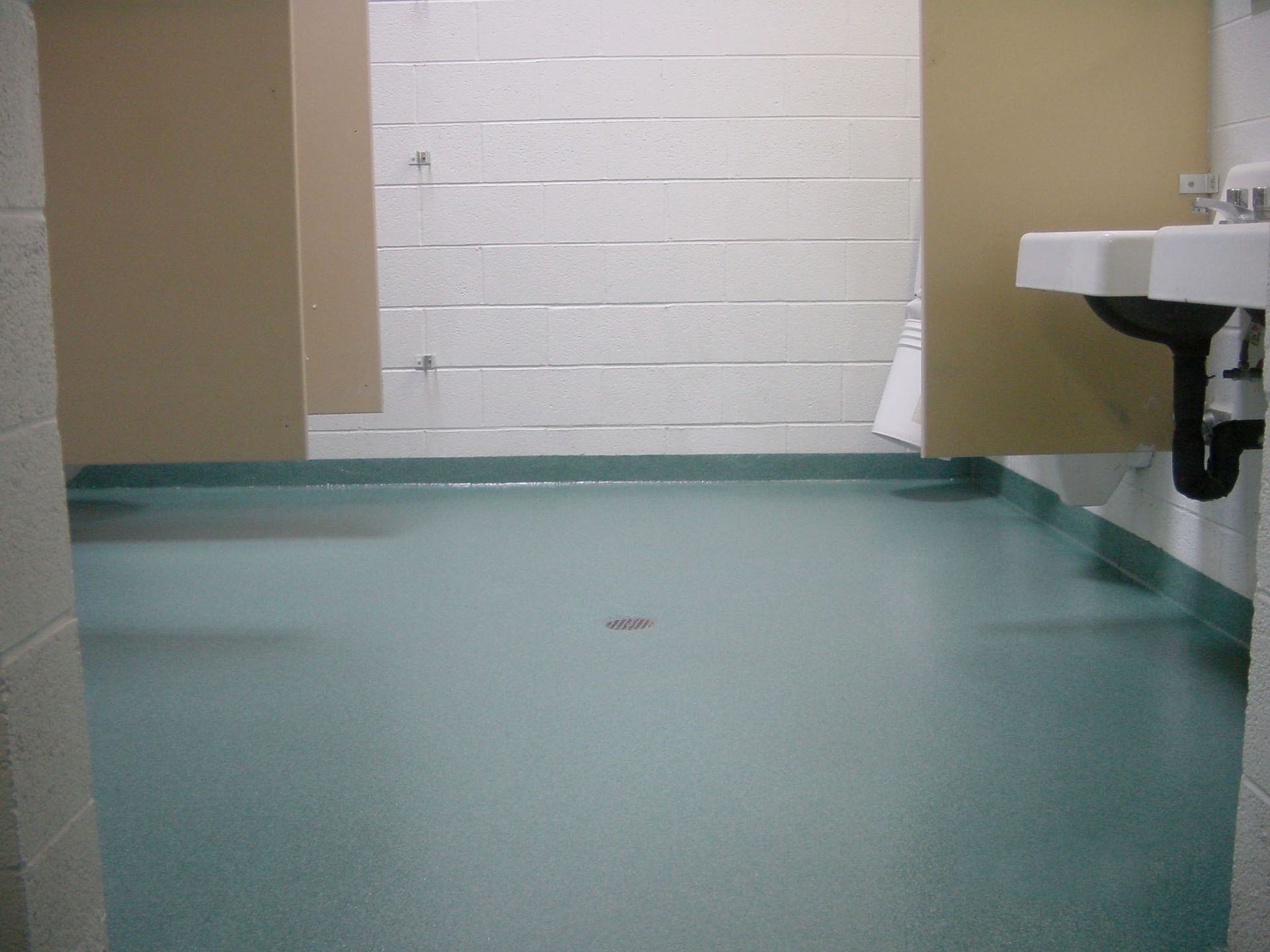 a bathroom with a green floor and a sink