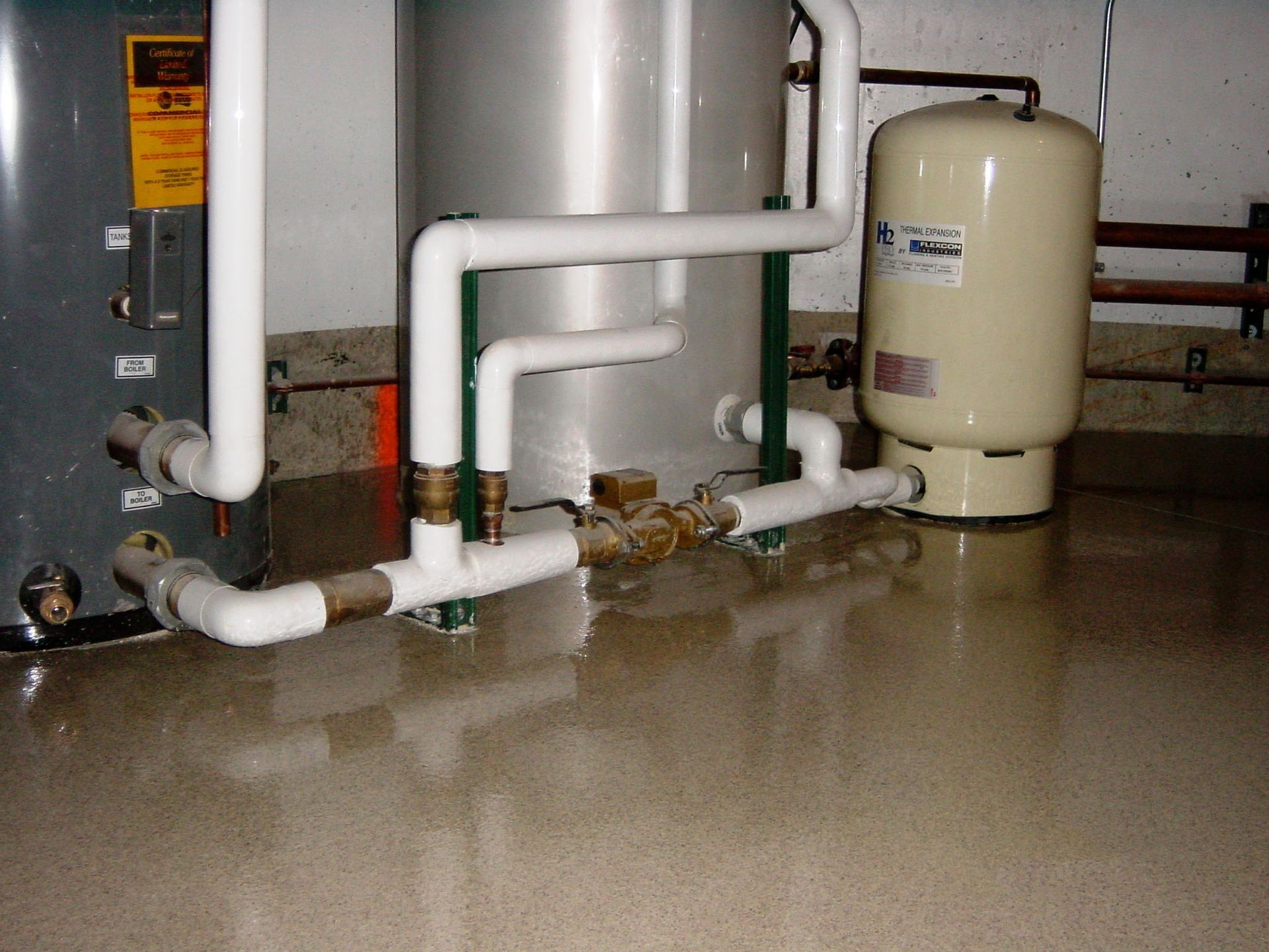 a water heater and a pressure tank in a basement