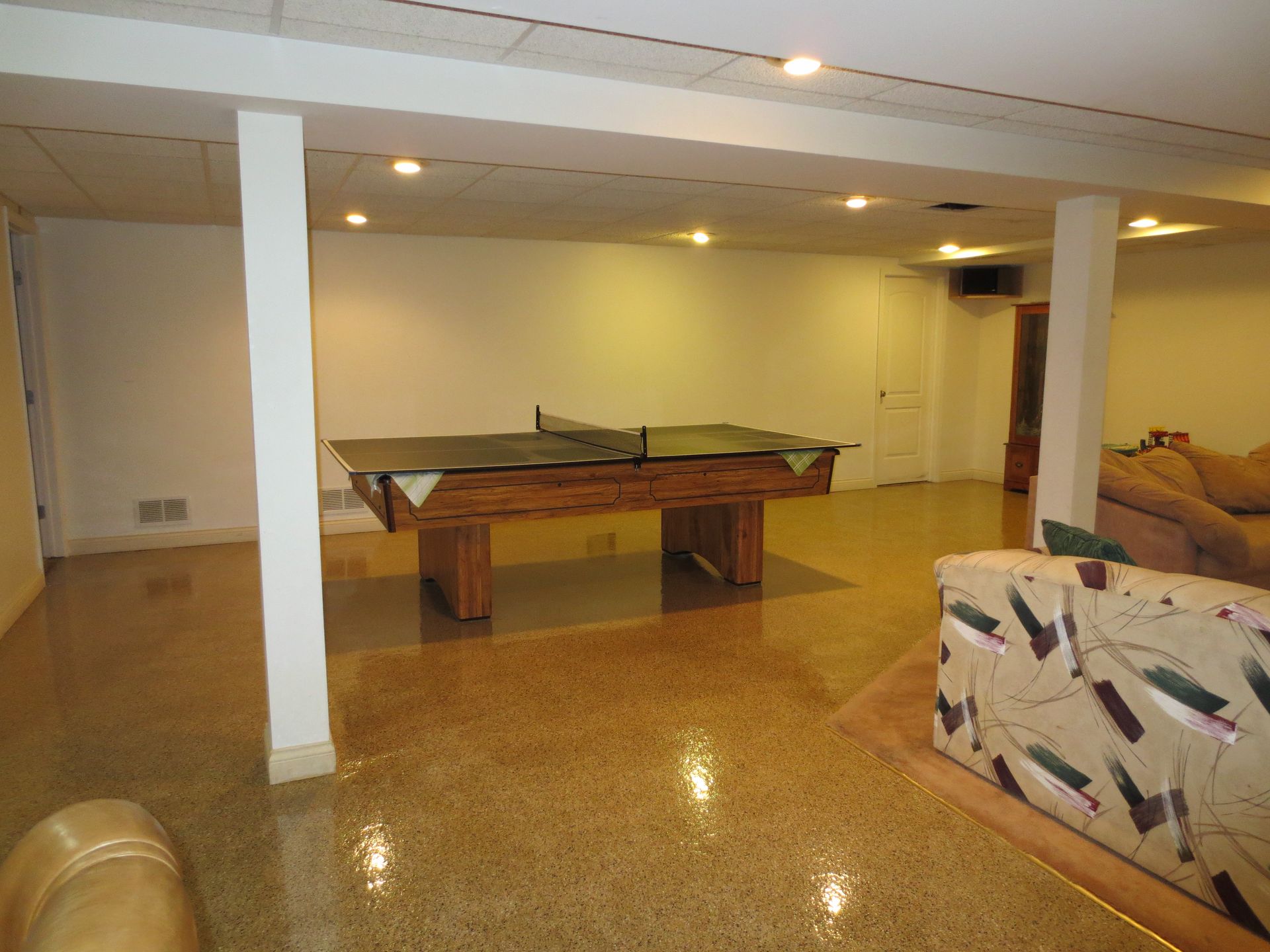 a basement with a pool table and a ping pong table