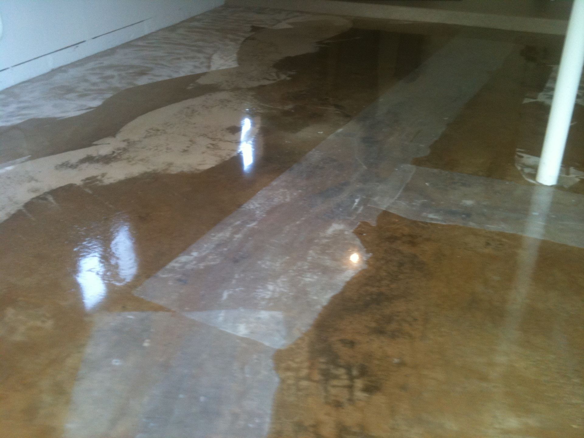 a concrete floor with a white pole in the background