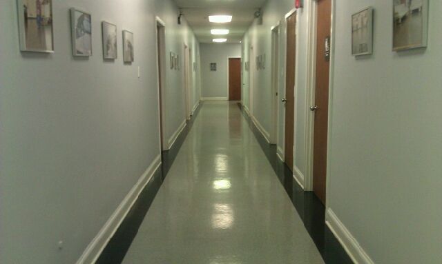 a long hallway with a lot of doors and pictures on the wall