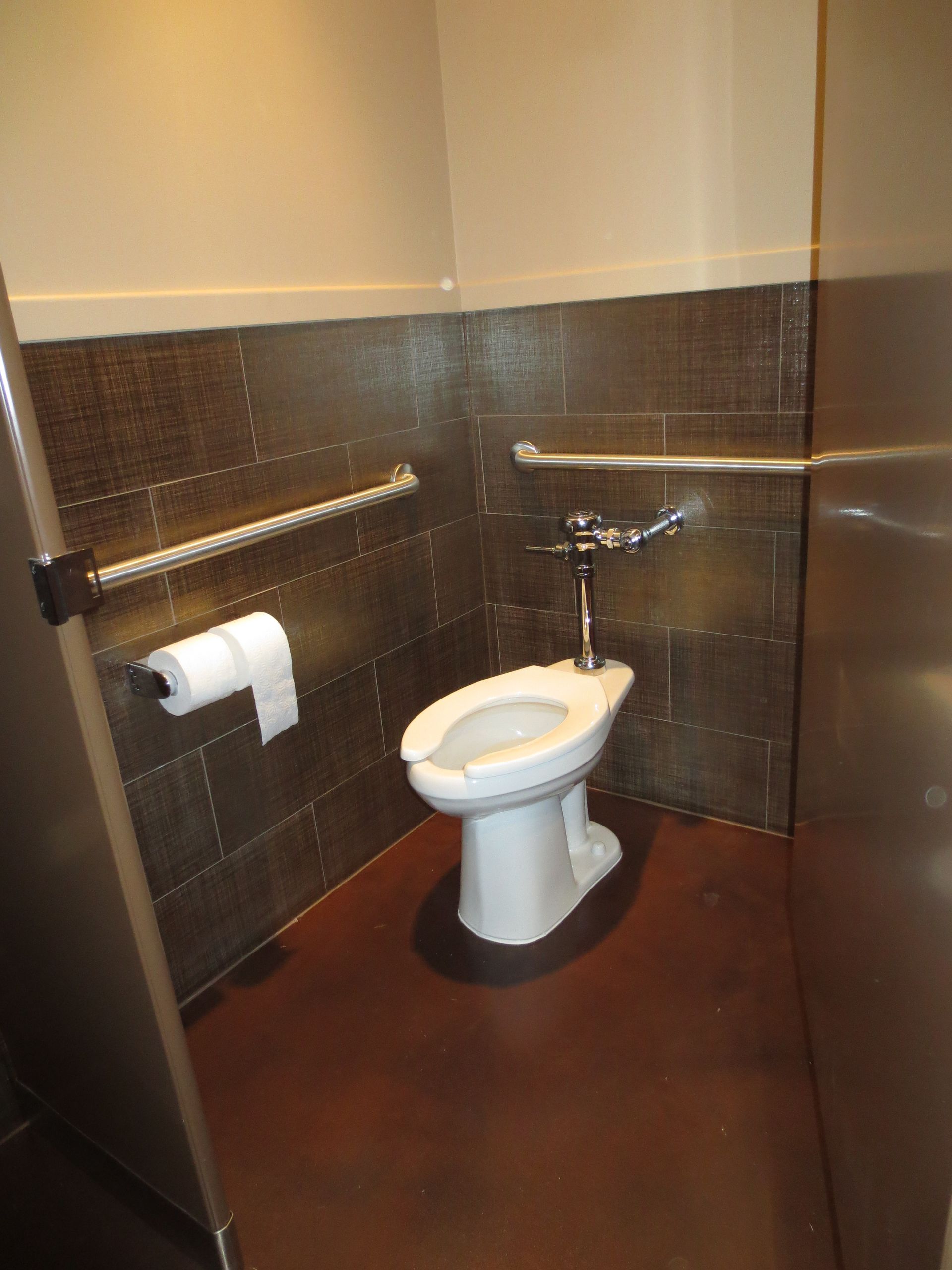 a bathroom with a toilet and a paper towel holder