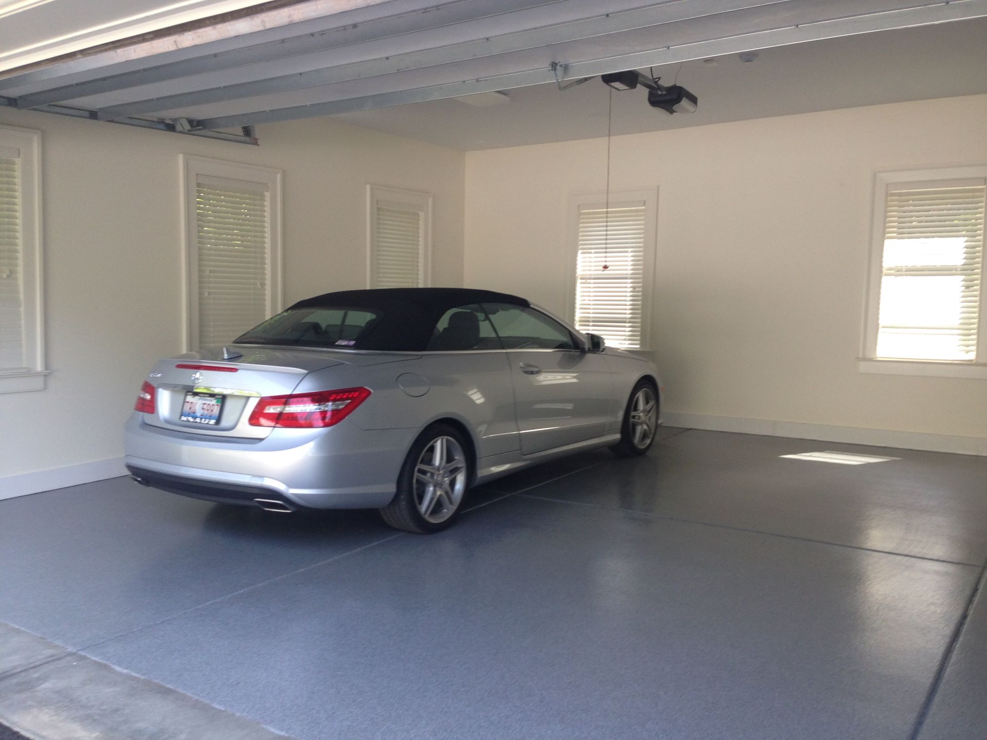 a silver convertible car is parked in a garage