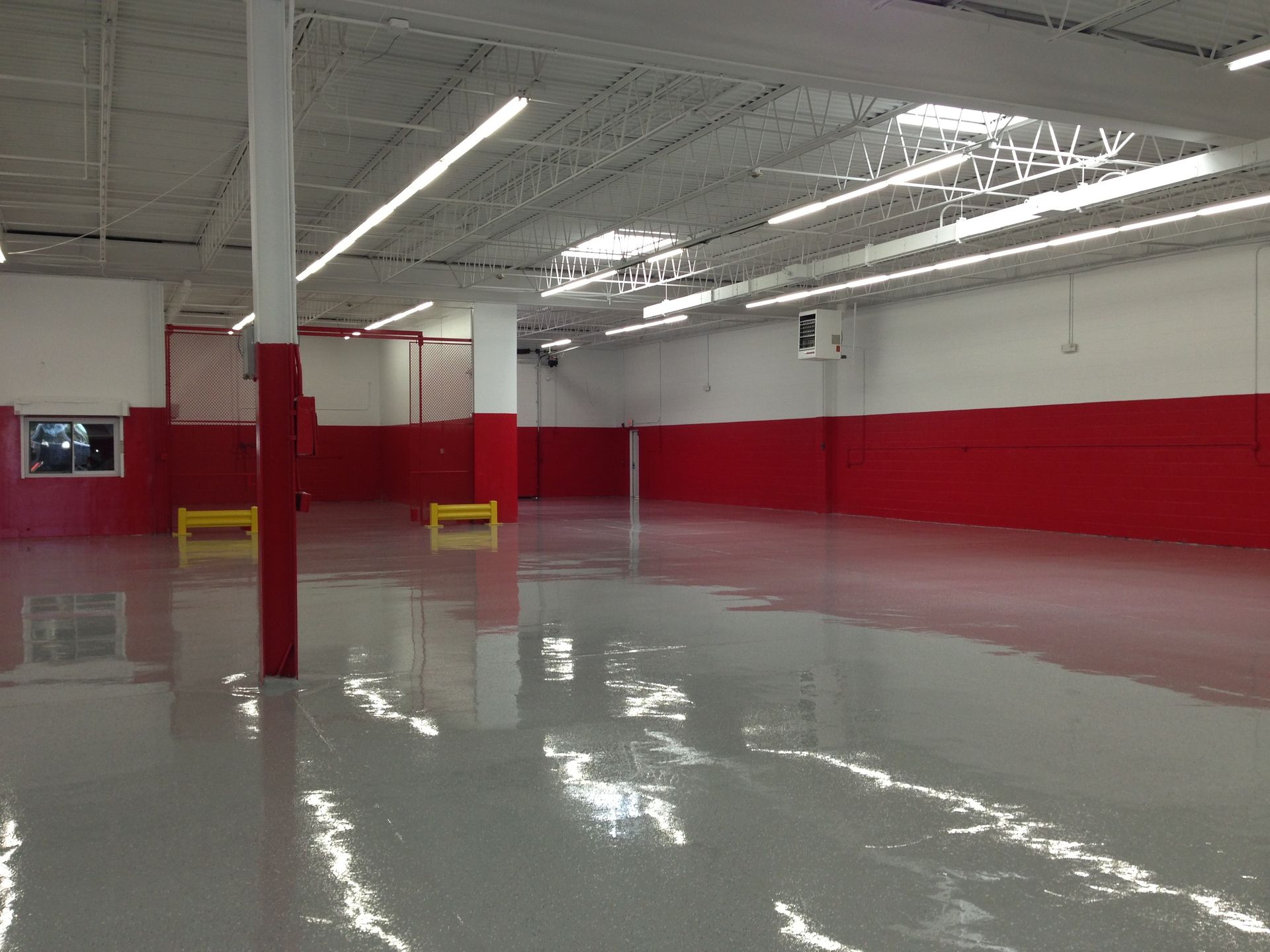 a large empty room with red walls and a gray floor